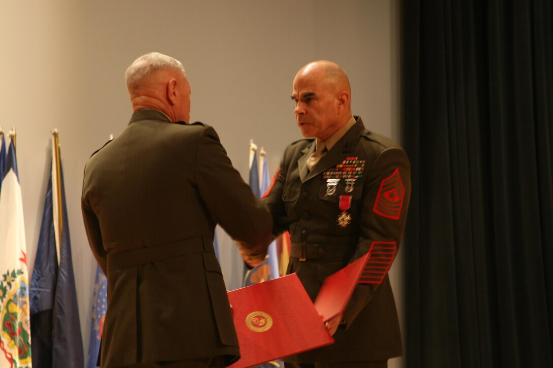 Lt. Gen. Kenneth J. Glueck, Jr. (left) handing the Legion of Merit award to Sgt. Maj. Gary W. Weiser (right). At the post and appointment ceremony, Weiser was relieved and Sgt. Maj. David L. Jobe took over as senior enlisted leader of MCCDC.