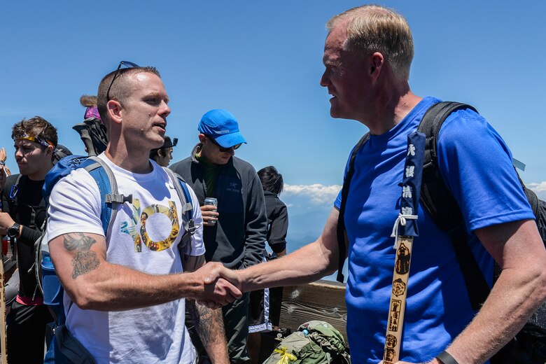An Airman thanks Chief Master Sgt. of the Air Force James A. Cody for hiking alongside members from Yokota Air Base at Mount Fuji, Japan, July 11, 2015. Cody invited Yokota AB personnel to join him on the hike so that he could take time to interact with them. (U.S. Air Force photo/Airman 1st Class Elizabeth Baker)