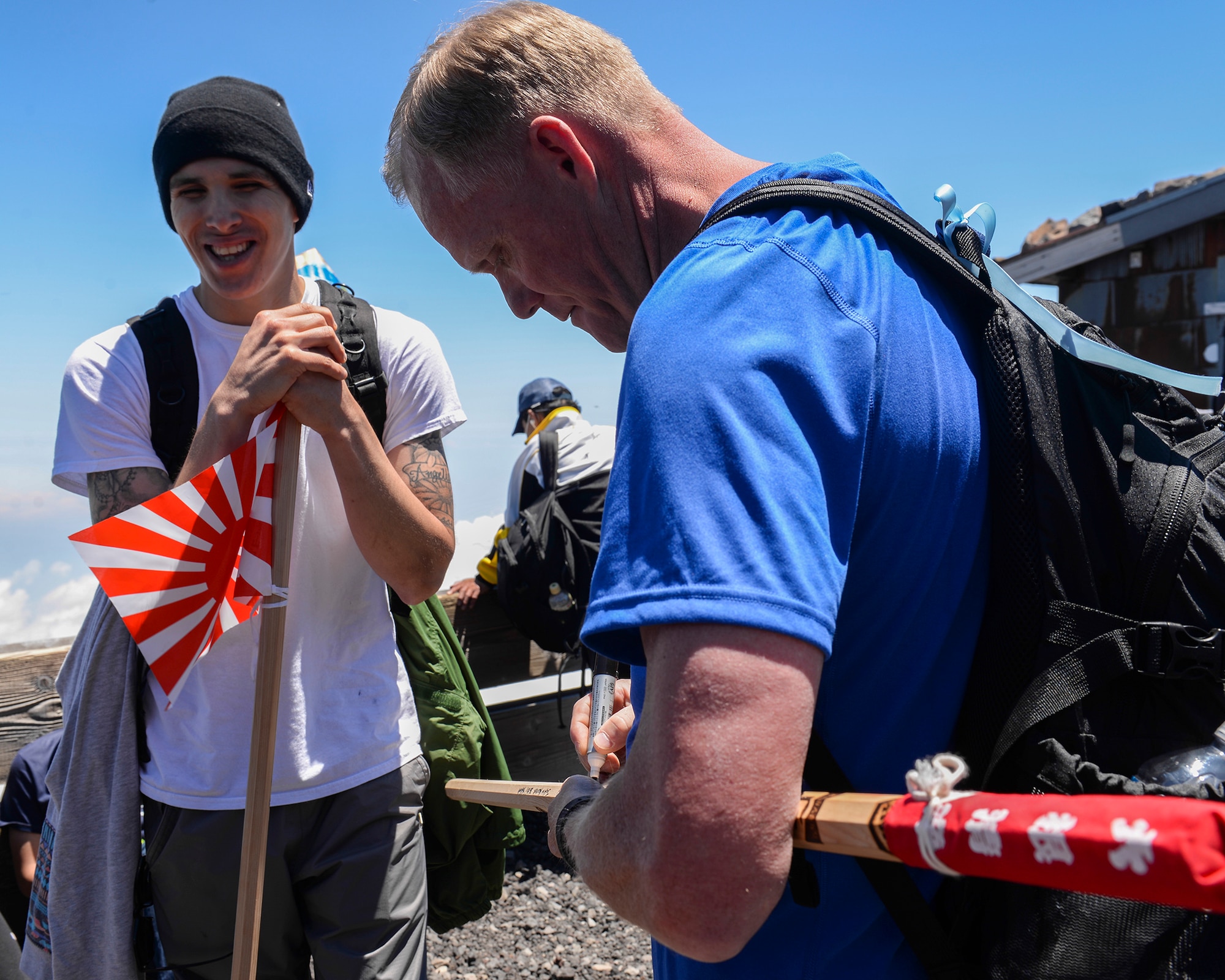 Chief Master Sgt. of the Air Force James A. Cody signs a walking stick for an Airman at the summit of Mount Fuji, Japan, July 11, 2015. During his trip to Japan, Cody extended an opportunity to 85 Yokota Air Base personnel to join him on a resiliency day trip to the summit of Mount Fuji. (U.S. Air Force photo/Airman 1st Class Elizabeth Baker)