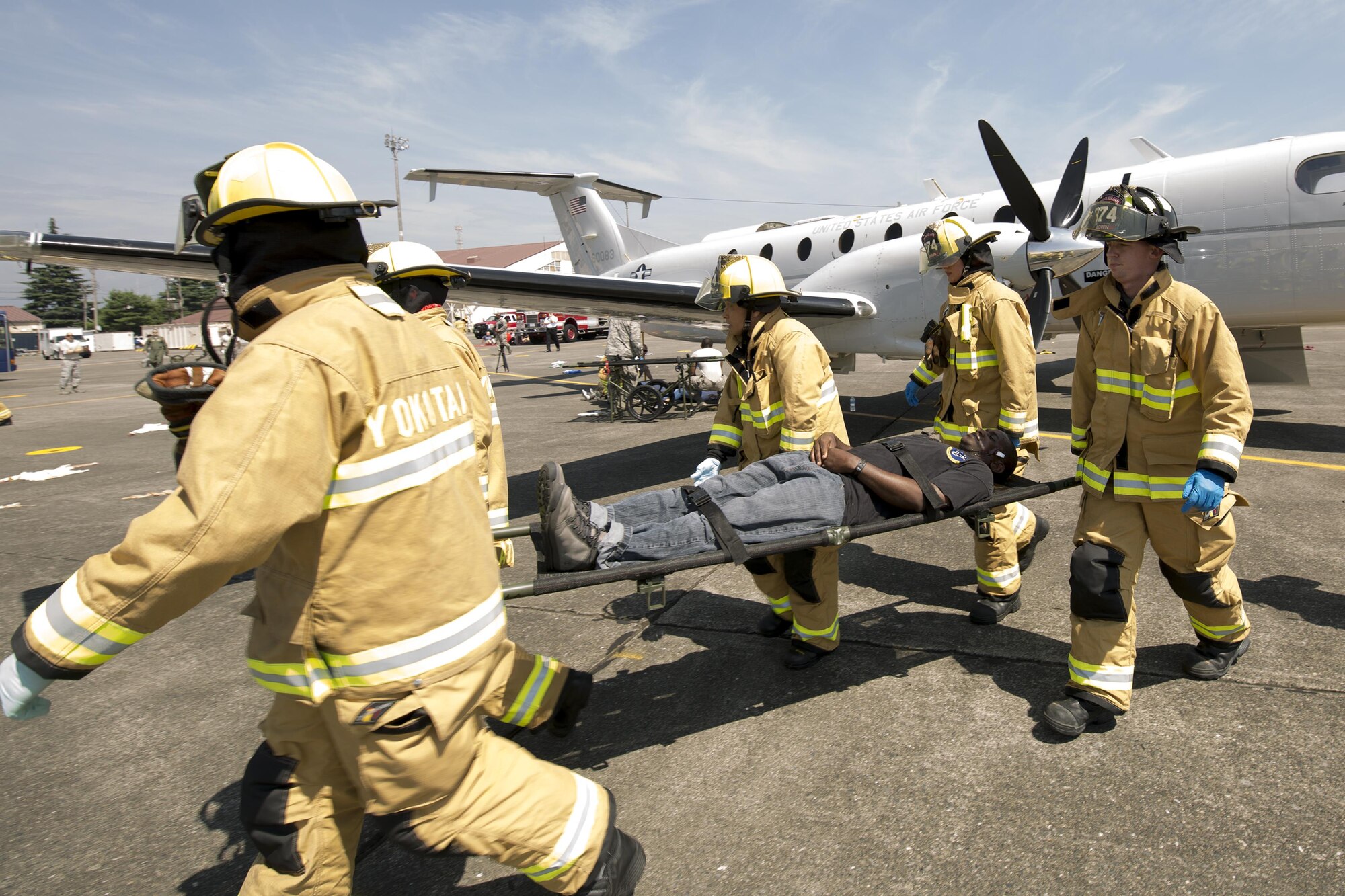 Yokota firefighters transport a simulated victim from an aircraft clash site during an Emergency Management Exercise at Yokota Air Base, Japan, July 13, 2015. Yokota conducted a Samurai Readiness Training Week to enhance readiness for real-world situations. (U.S. Air Force photo by Osakabe Yasuo/Released)
