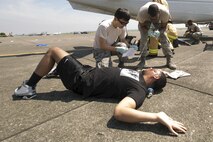 First responders from the 374th Medical Group arrive on scene and assess the situation during an Emergency Management Exercise at Yokota Air Base, Japan, July 13, 2015. The EME trained Yokota for possible real-world situations requiring response and communication between on-base organizations. (U.S. Air Force photo by Osakabe Yasuo/Released)
