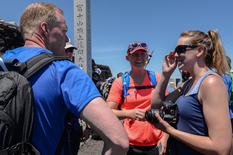 Chief Master Sergeant of the Air Force James A. Cody interacts with Airmen at the summit of Mount Fuji, Japan, July 11, 2015. Cody spent time getting to know many of the hikers, taking time to pose for pictures, sign walking sticks and talk to the Airmen. (U.S. Air Force photo by Airman 1st Class Elizabeth Baker/Released)