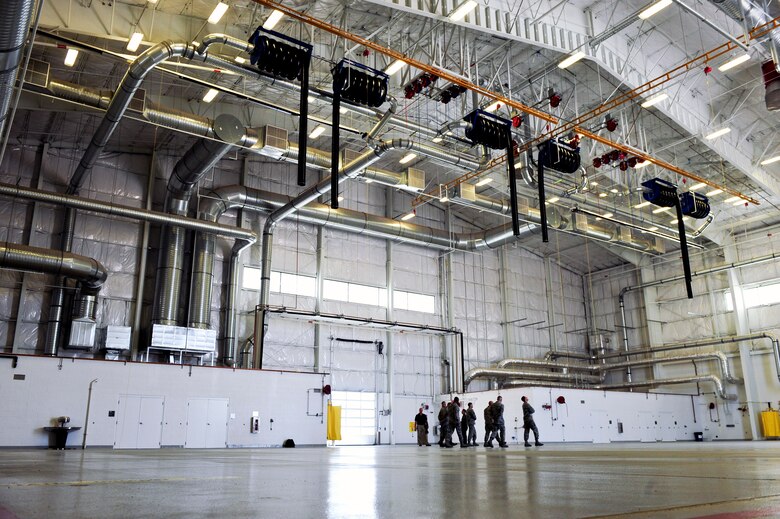 U.S. Air Force Airmen tour the Component Maintenance Squadron's Joint fuel cell repair hangar after its ribbon cutting ceremony at Davis-Monthan Air Force Base, Ariz., July 13, 2015. The facility was constructed to improve efficiency within the joint fuel cell, leading to the reduction in man hours and operating costs. (U.S. Air Force photo by Airman 1st Class Chris Drzazgowski/Released)