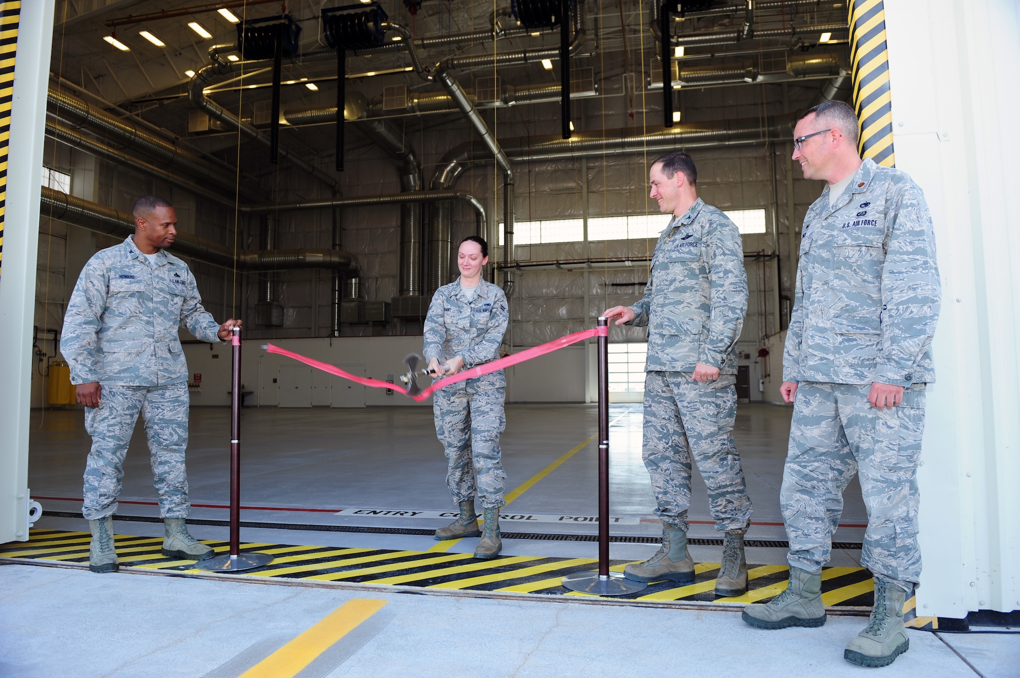 U.S. Air Force Airman 1st Class Desaray Grant, 355th Component Maintenance Squadron aircraft fuel systems apprentice, slashes through a ribbon signifying the activation of the 355th CMS's new Joint fuel cell repair hangar at Davis-Monthan Air Force Base, Ariz., July 13, 2015. The hangar is Air Combat Command's largest aircraft fuel systems repair section. (U.S. Air Force photo by Airman 1st Class Chris Drzazgowski/Released)