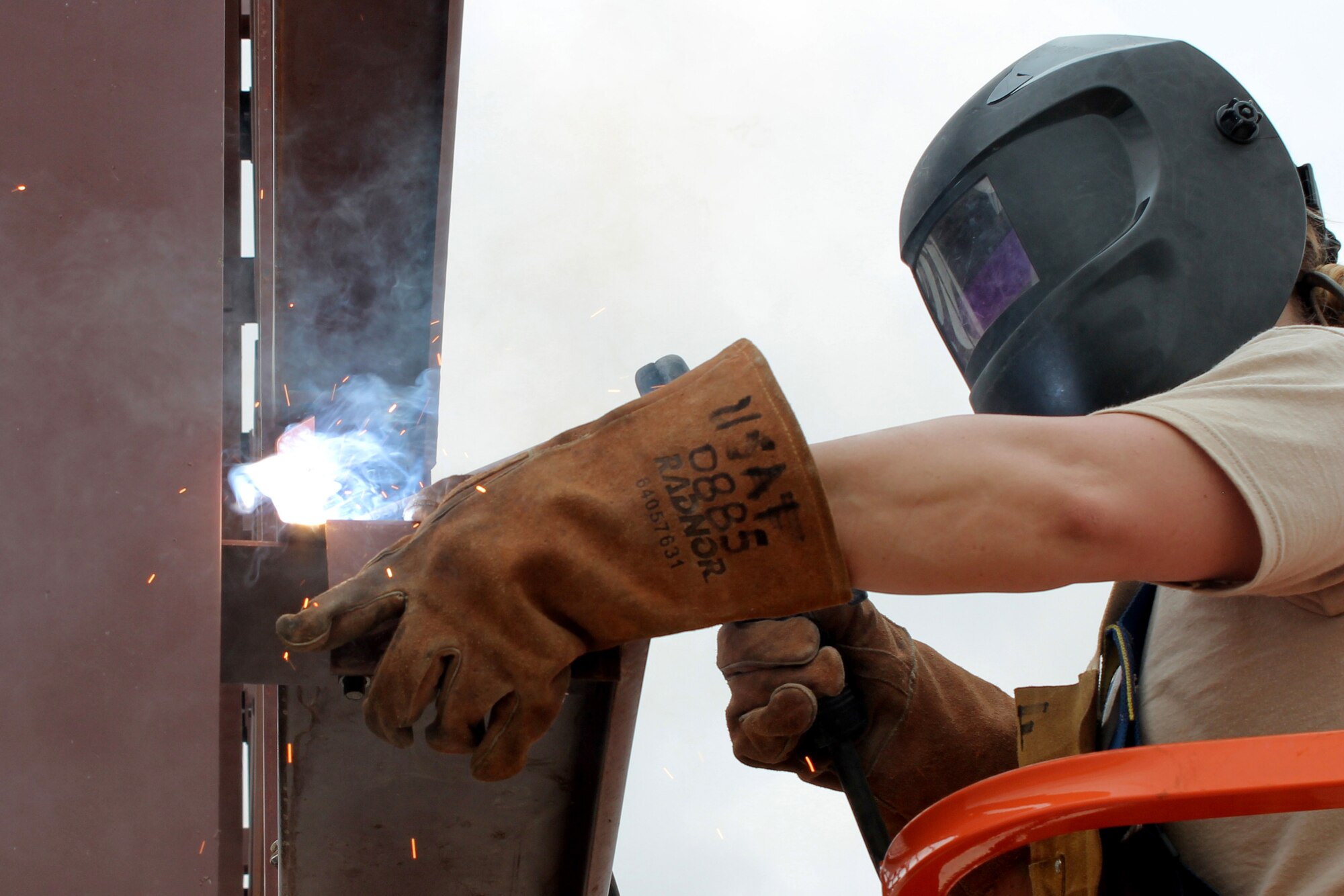 Sparks fly as a U.S. Air Force Airman welds a piece of angle iron to the frame of a new airplane hangar in Clarksdale, Miss., June 30, 2015.   The new hangar is being constructed at the city's airport as part of the Innovative Readiness Training initiative, an Air Force Reserve Command program that helps underserved communities while simultaneously providing real-world training for troops. (U.S. Air Force photo by Senior Airman Rodney Gibson/released)