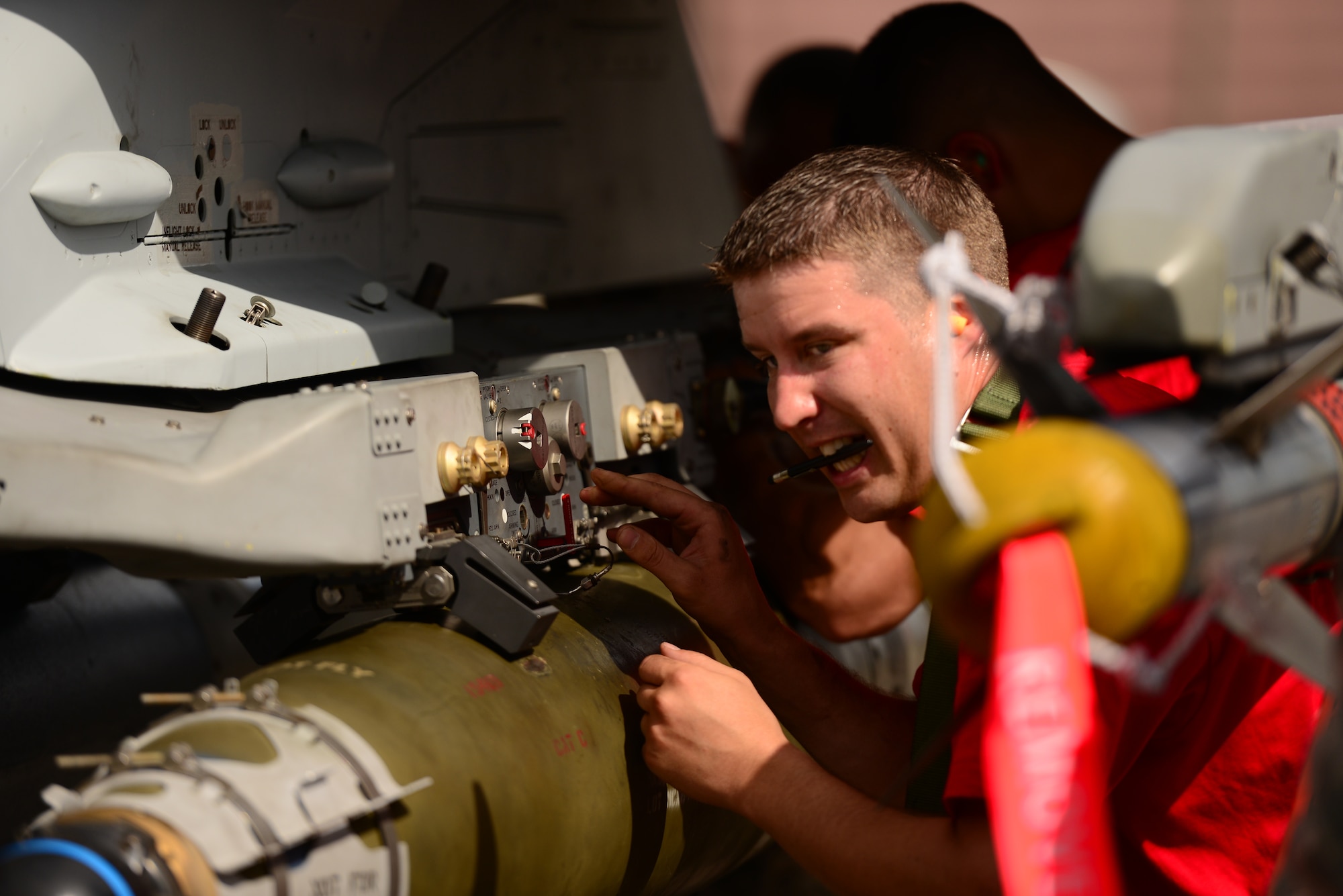 Staff Sgt. Kevin Vinson, 36th Aircraft Maintenance Unit weapons loader, directs the loading of practice munitions during the quarterly load competition held at Osan Air Base, Republic of Korea, July 10, 2015. The event adds an element of competition to a qualification test for the technicians; competitors must complete a written test and a practical demonstration of skill within a fixed amount of time in order to maintain mission readiness status. (U.S. Air Force photo/Staff Sgt. Amber Grimm)