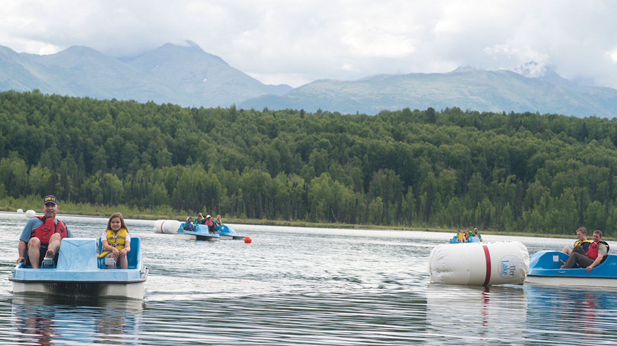 Father-daughter team Gary and Leilani Lewis, 8, far left, compete in a paddle boat race during Otterfest on Joint base Base Elmendorf-Richardson, Alaska, July 11, 2015. Air Force Capt. Gary Lewis is a chaplain for the 673d Air Base Wing Chapel. Otter Fest was organized and hosted by the JBER Outdoor Recreation Center. (U.S. Air Force photo/Tech. Sgt. Robert Barnett)