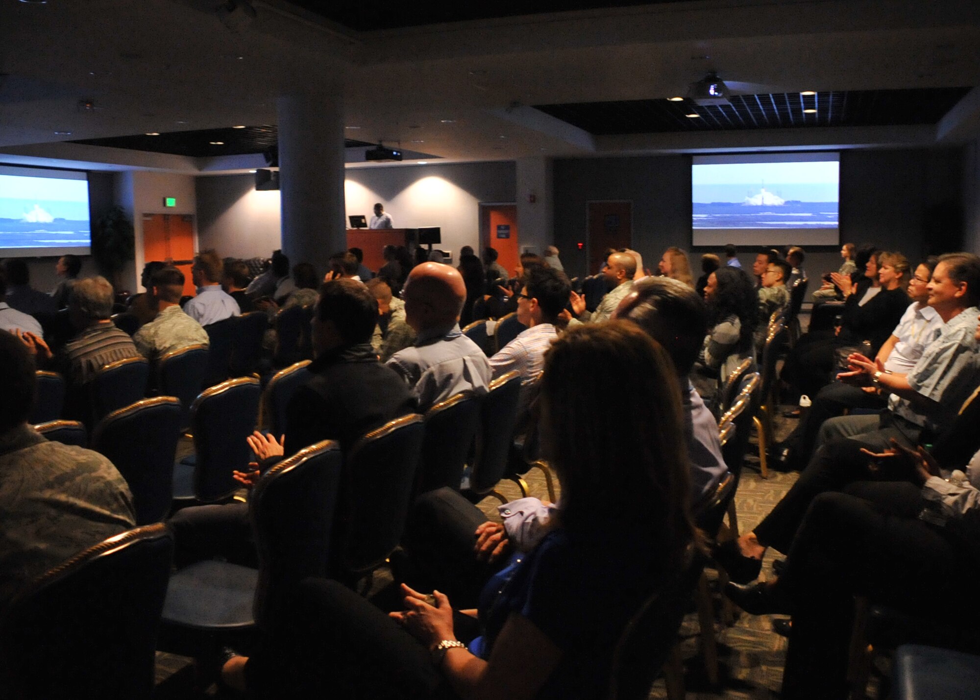 An audience of more than 150 Space and Missile Systems Center personnel applaud the launch of an Atlas V in the Gordon Conference Center at Los Angeles Air Force Base in El Segundo, Calif. On July 15, 2015, a United Launch Alliance Atlas V in the “401” vehicle configuration of a four-meter-wide payload fairing, zero solid rocket boosters and a single engine upper stage successfully carried a GPS IIF-10 satellite into orbit at 11:36 a.m. EDT from Launch Complex 41 at Cape Canaveral Air Force Station in Florida for the Global Positioning System navigation network. (U.S. Air Force photo/Sarah Corrice)