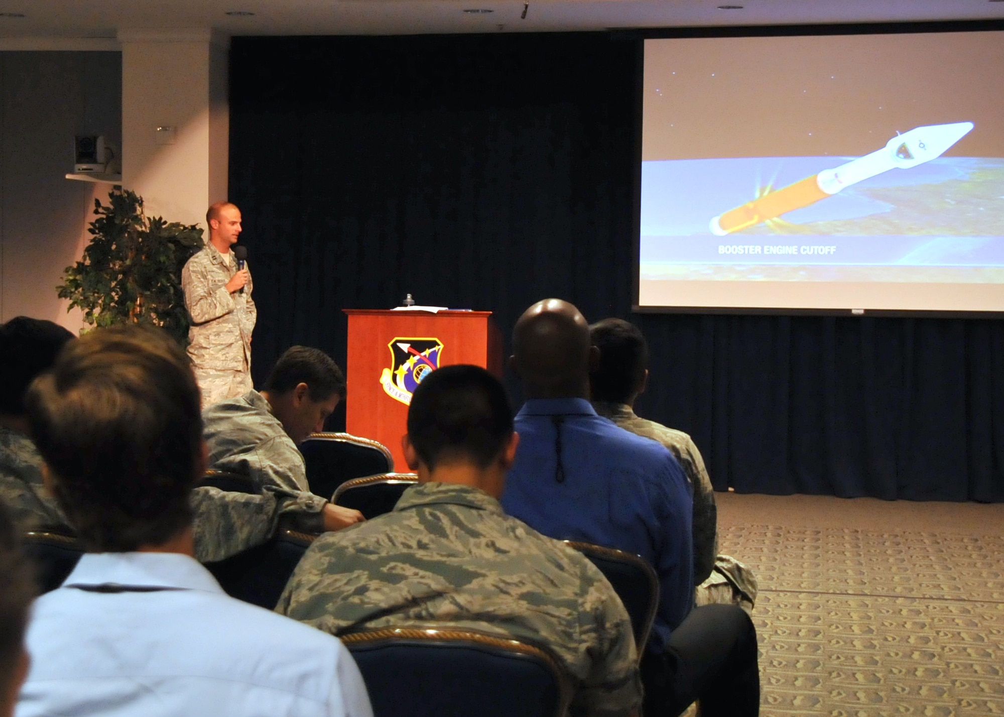 Narrating a PowerPoint presentation Capt. Nick Laliberte, Government Mission Integration Manager from the Space and Missile Systems Center’s Launch Systems Directorate briefs an audience of more than 150 SMC personnel in the Gordon Conference Center at Los Angeles Air Force Base in El Segundo, Calif. On July 15, 2015, a United Launch Alliance Atlas V in the “401” vehicle configuration of a four-meter-wide payload fairing, zero solid rocket boosters and a single engine upper stage successfully carried a GPS IIF-10 satellite into orbit at 11:36 a.m. EDT from Launch Complex 41 at Cape Canaveral Air Force Station in Florida for the Global Positioning System navigation network. (U.S. Air Force photo/Sarah Corrice)