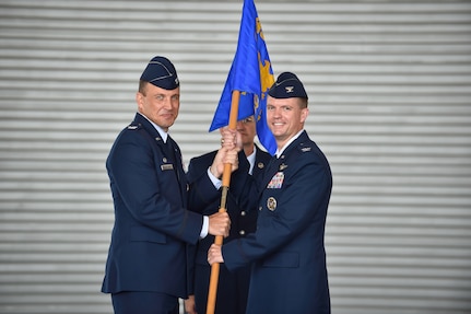 Colonel John Lamontagne (left), 437th Airlift Wing commander, passes the guidon to Col. Scovill Currin July 15, 2015, during the 437th Operations Group change of command at Joint Base Charleston, S.C. Currin assumed command of the 437th OG from Col. Fred Boehm during the ceremony. Currin has spent the last three years at Duke University in Durham, N.C., earning his doctorate in history. Boehm, who has commanded the 437th OG since July 2013 is headed to Saudi Arabia where he will be the chief of the Joint Advisory Division for Saudi Arabia. (U.S. Air Force photo/Senior Airman Jared Trimarchi) 