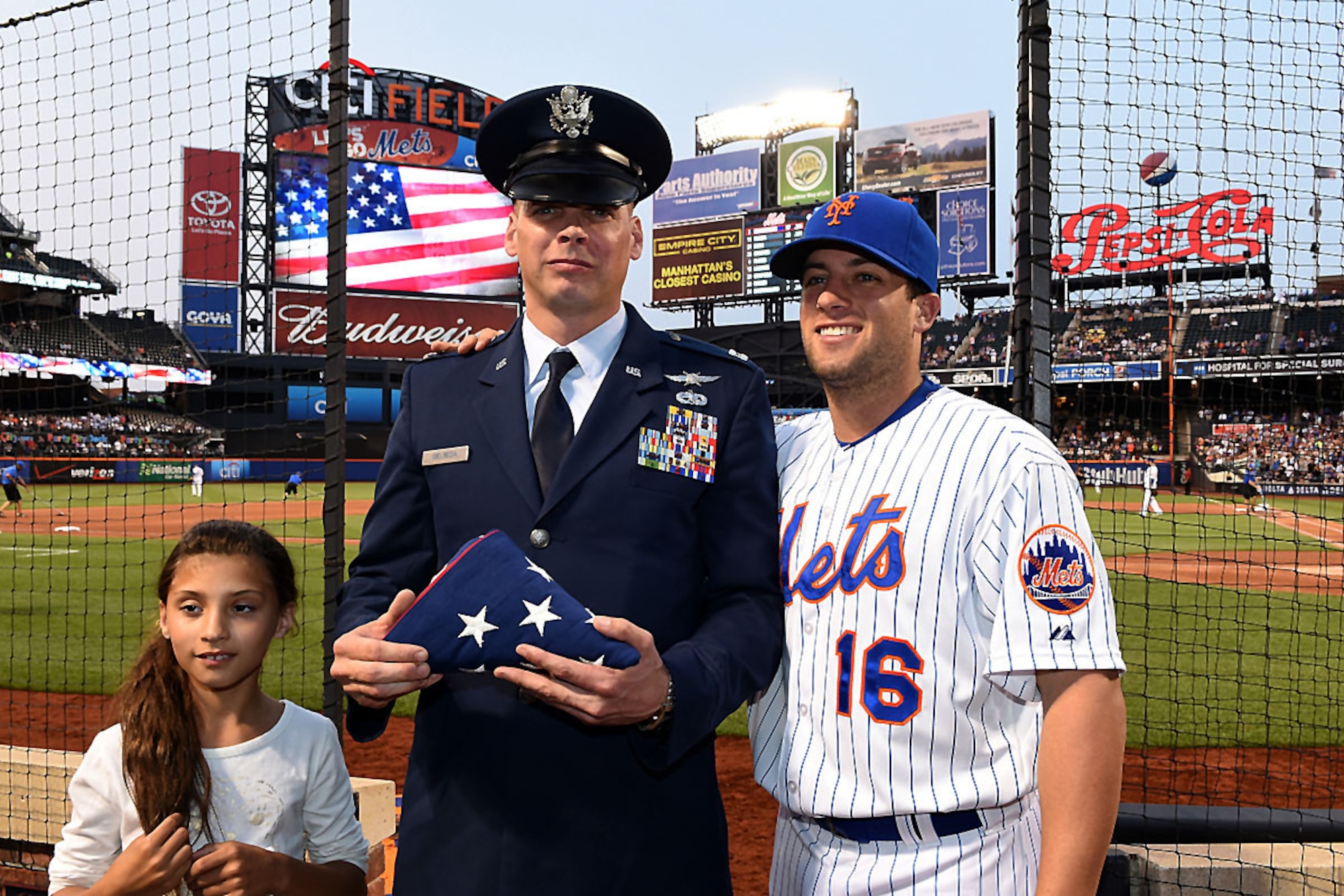 Mets second baseman, Danny Muno, posses with Capt. Michael Gielbeda, communications and information officer with the 111th Operations Support Squadron and his daughter, June 9 at Citi Field, Queens, N.Y. Gielbeda was recognized as the Veteran of the Game by the Mets and the Wounded Warrior Project during the game against the San Francisco Giants. (Image provided by Capt. Michael Gielbeda)