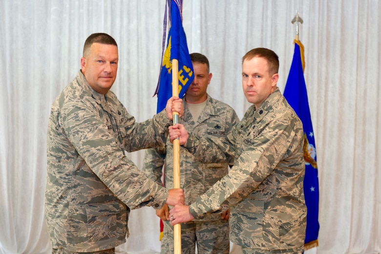 Col. Matthew Wallace, 45th Mission Support Group commander, left, presents Lt. Col. Jason Glynn, 45th Civil Engineer Squadron commander, with the 45th CES guidon during a change of command ceremony July 14, 2015, at Patrick Air Force Base, Fla. Changes of command are a military tradition representing the transfer of responsibilities from the presiding officials to the upcoming official. (U.S. Air Force photo/Cory Long) (Released)