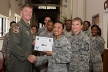 Senior Airman Denise Hill, center, 47th Force Support Squadron career development journeyman, poses with Col. Thomas Shank, 47th Flying Training Wing commander, and Chief Master Sgt. Teresa Clapper, 47th FTW command chief, after accepting the XLer of the Week award, here, July 9, 2015. The XLer is a weekly award chosen by wing leadership and is presented to those who consistently make outstanding contributions to their unit and Laughlin. (U.S. Air Force photo by Airman 1st Class Brandon May)