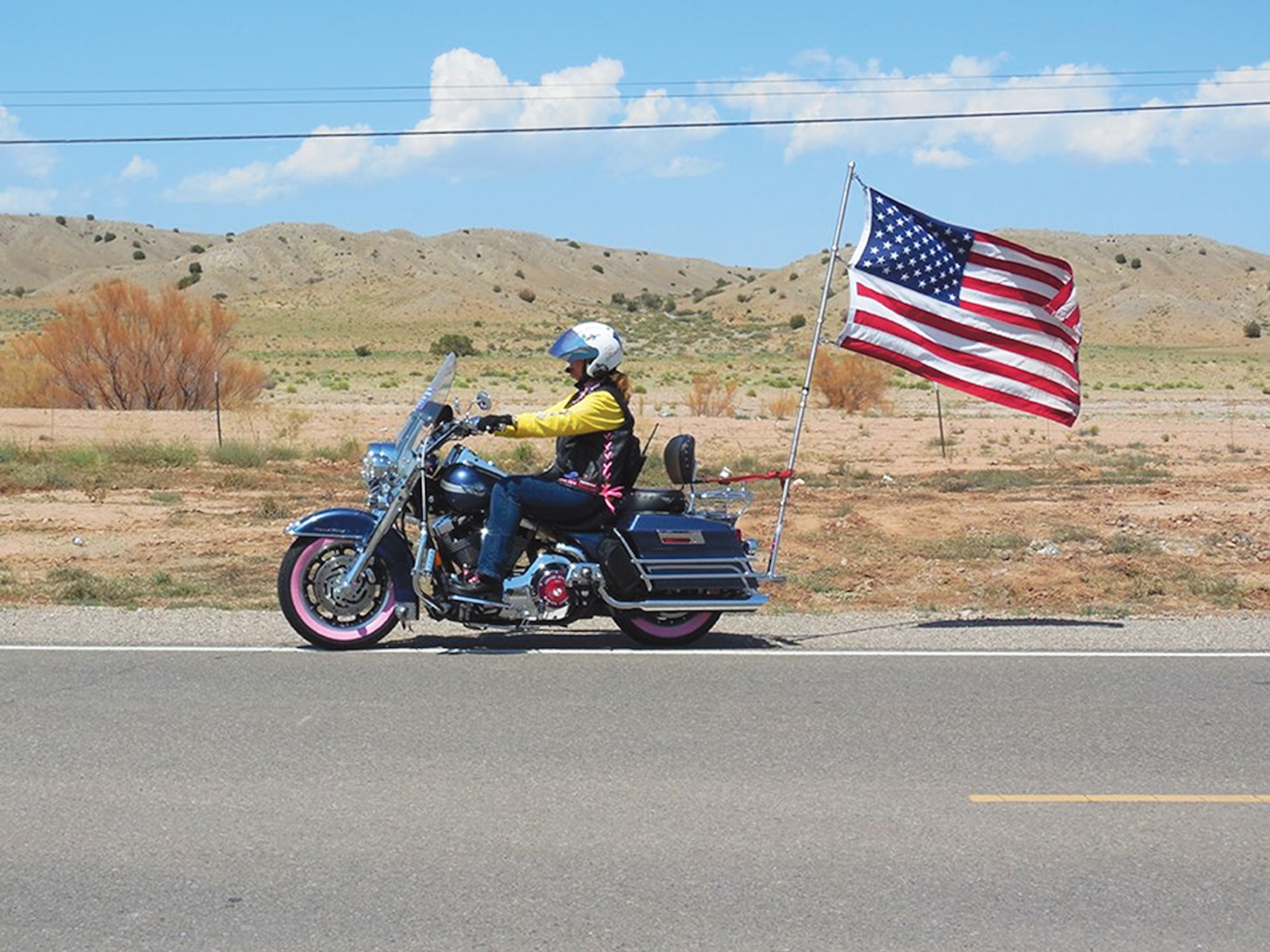 A rider in the 2014 Nation of Patriots ride takes that year’s flag on a ride near Santa Fe, N.M. The group pays tribute to the military on a ride through 48 states and raises money to support military families. (Courtesy photo)