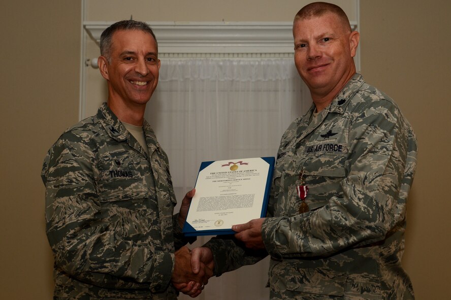 U.S. Air Force Lt. Col. David McCoy, outgoing 20th Communications Squadron commander, receives the Meritorious Service Medal from Col. John Thomas, 20th Mission Support Group commander, during the 20th CS change of command ceremony at Shaw Air Force Base, S.C., July 15, 2015. The 20th CS provides superior communications, mission-ready cyber capabilities and support forces to enable command and control for Team Shaw and worldwide operations. (U.S. Air Force photo by Senior Airman Jonathan Bass/Released)