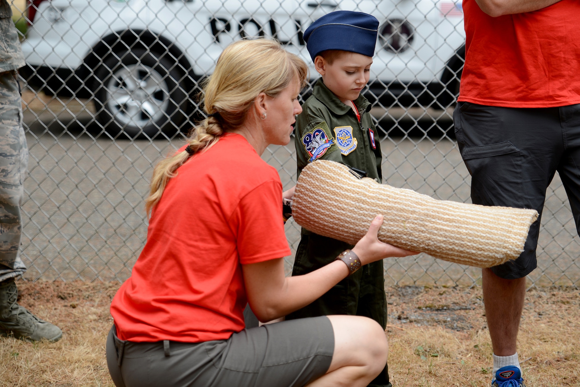 Ewan McFadgen, Pilot for a Day, puts on a dog handlers arm wrap with the assistance of his mother, Melissa, July 10, 2015, during his tour of Joint Base Lewis-McChord, Wash. The Directorate of Emergency Services canine unit dog handlers showed Ewan and his family how they use the arm wrap to train their dogs. (U.S. Air Force photo/Airman 1st Class Keoni Chavarria)