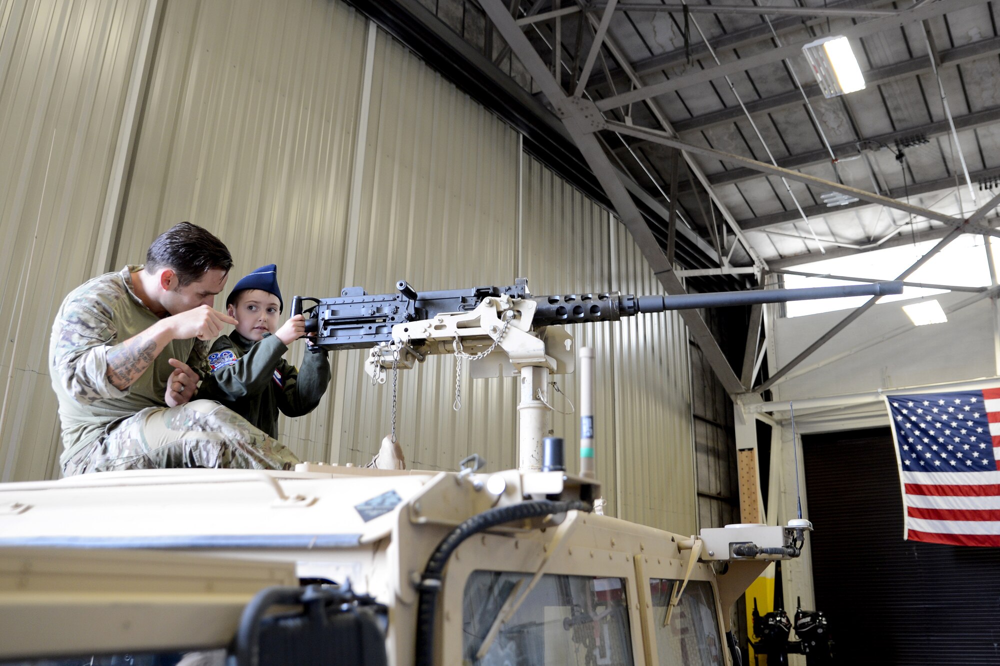 Ewan McFadgen, Pilot for a Day, sits in a turret of an armored Humvee with a combat controller at the 22nd Special Tactics Squadron, July 10, 2015, during his tour of Joint Base Lewis-McChord, Wash. While at the 22nd STS, McFadgen visited the air traffic control simulator and was able to listen to the commands over the radio. (U.S. Air Force photo/Airman 1st Class Keoni Chavarria)