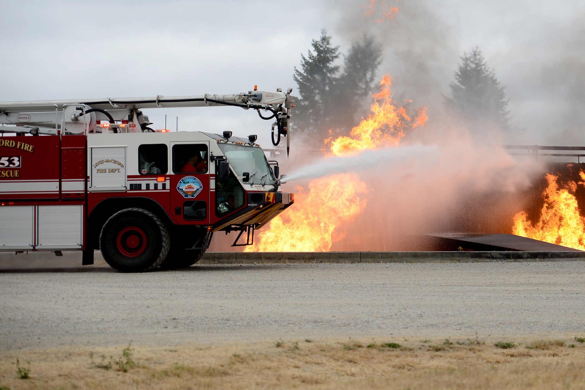 Ewan McFadgen, Pilot for a Day, controls the water hose in a McChord Field fire truck to put out a controlled fire July 10, 2015, during his tour of Joint Base Lewis-McChord, Wash. The Pilot for a Day program gives children affected with a catastrophic illness, on their way to recovery, a tour of JBLM. (U.S. Air Force photo/Airman 1st Class Keoni Chavarria)
