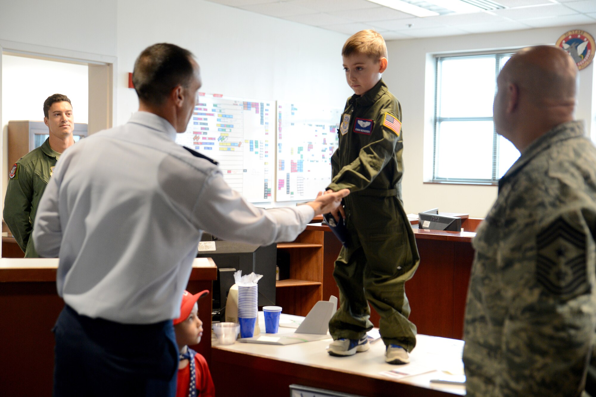 Ewan McFadgen, Pilot for a Day, receives a coin by Col. Leonard Kosinski, 62nd Airlift Wing commander, July 10, 2015, during his tour of Joint Base Lewis-McChord, Wash. McFadgen is Team McChord’s newest Pilot for a Day and received a tour of the base here. (U.S. Air Force photo/Airman 1st Class Keoni Chavarria)