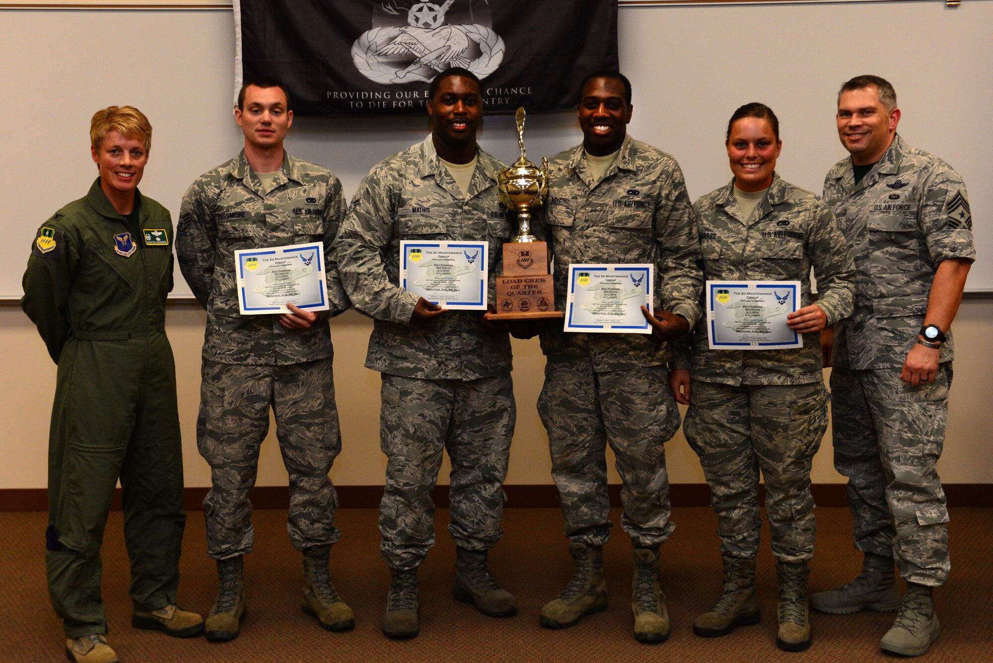 Col. Kristin Goodwin, 2nd Bomb Wing commander, and Chief Master Sgt. Tommy Mazzone, 2nd BW command chief, pose with Staff Sgt. Felix Passmore, Senior Airman Charlie Mathis, Airman 1st Class Jamouri Moye and Airman 1st Class Kristen Juarez, winners of the 2nd Maintenance Group load crew of the quarter competition on Barksdale Air Force Base, La., July 10, 2015. The competition is an important opportunity for Airmen to demonstrate their mission readiness and sharpen their skills. (U.S. Air Force photo/Airman 1st Class Luke Hill)