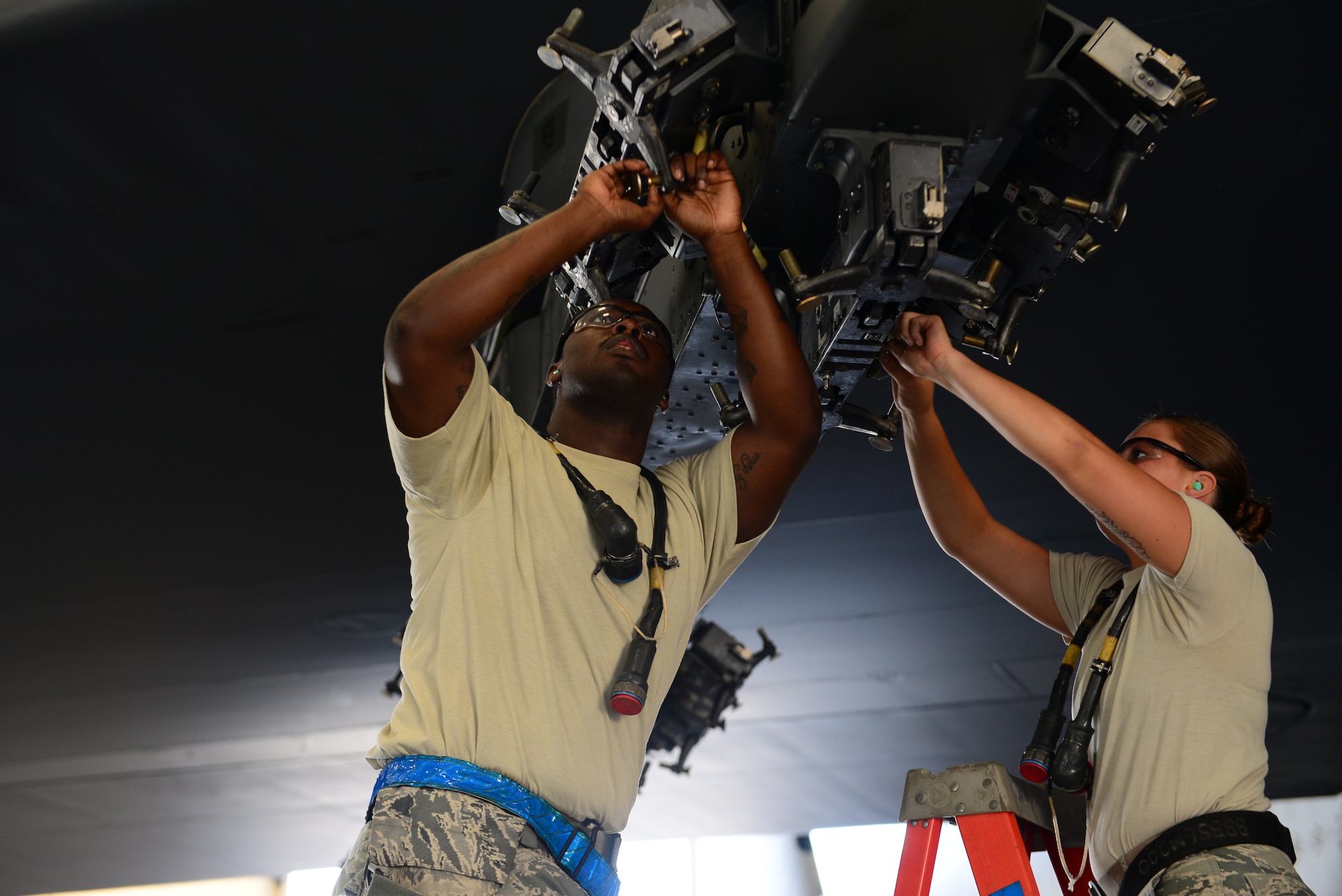 Senior Airman Charlie Mathis and Airman 1st Class Kristen Juarez, 2nd Aircraft Maintenance Squadron, prepare to load two CBU-103’s on a B-52 Stratofortress inside the weapons load training facility during a load crew of the quarter competition on Barksdale Air Force Base, La., July 10, 2015. Two four-man teams from the 2nd AMXS competed to see which team could inspect, prepare and load weapons onto a B-52 with the least amount of discrepancies. (U.S. Air Force photo/Airman 1st Class Luke Hill)