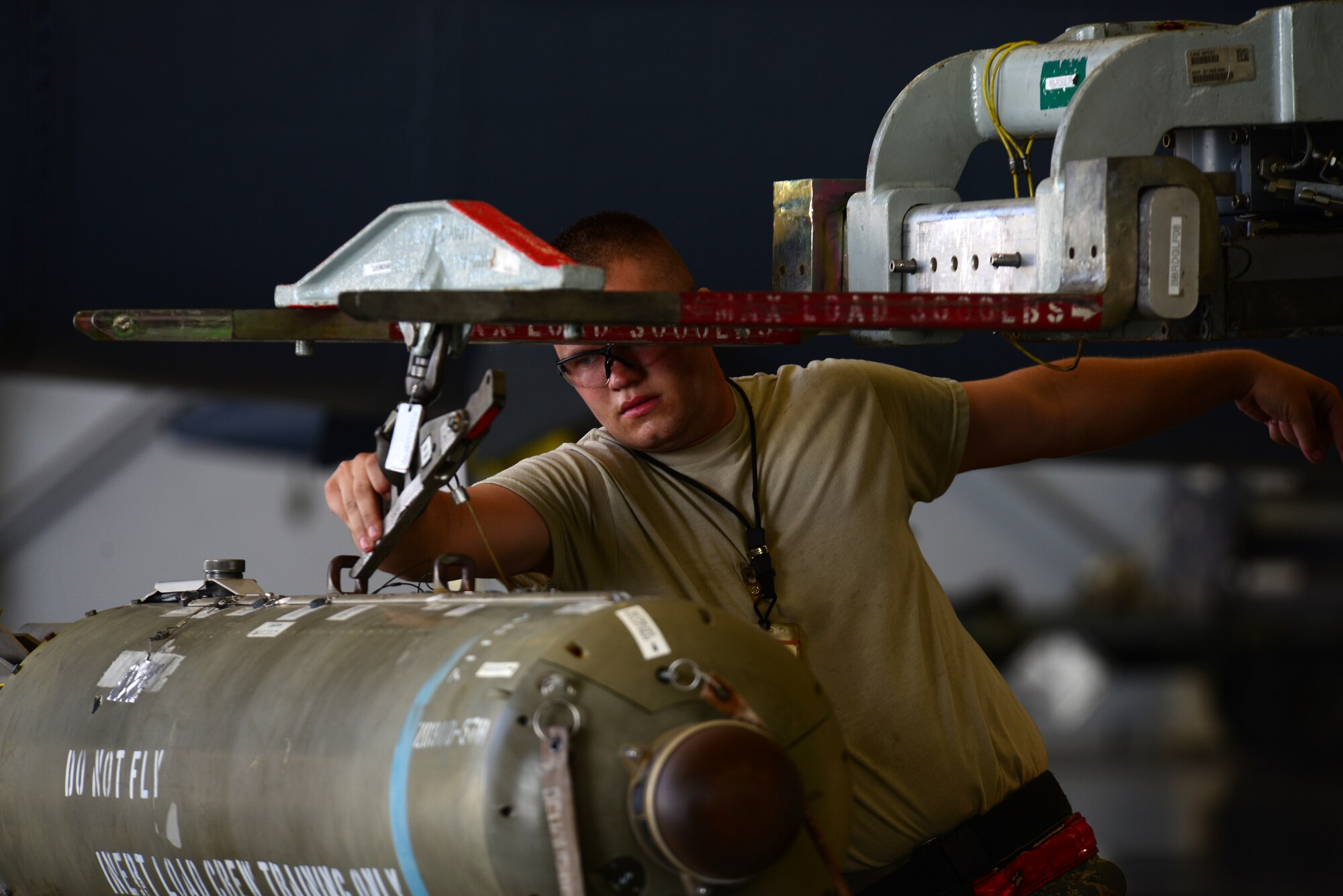Senior Airman David Hansen, 2nd Aircraft Maintenance Squadron, guides a bomb onto a lift during a load crew of the quarter competition at Barksdale Air Force Base, La., July 10, 2015. The competition judged weapons loading teams on how quickly and safely they were able to load weapons onto a B-52 Stratofortress. (U.S. Air Force photo/Airman 1st Class Luke Hill)