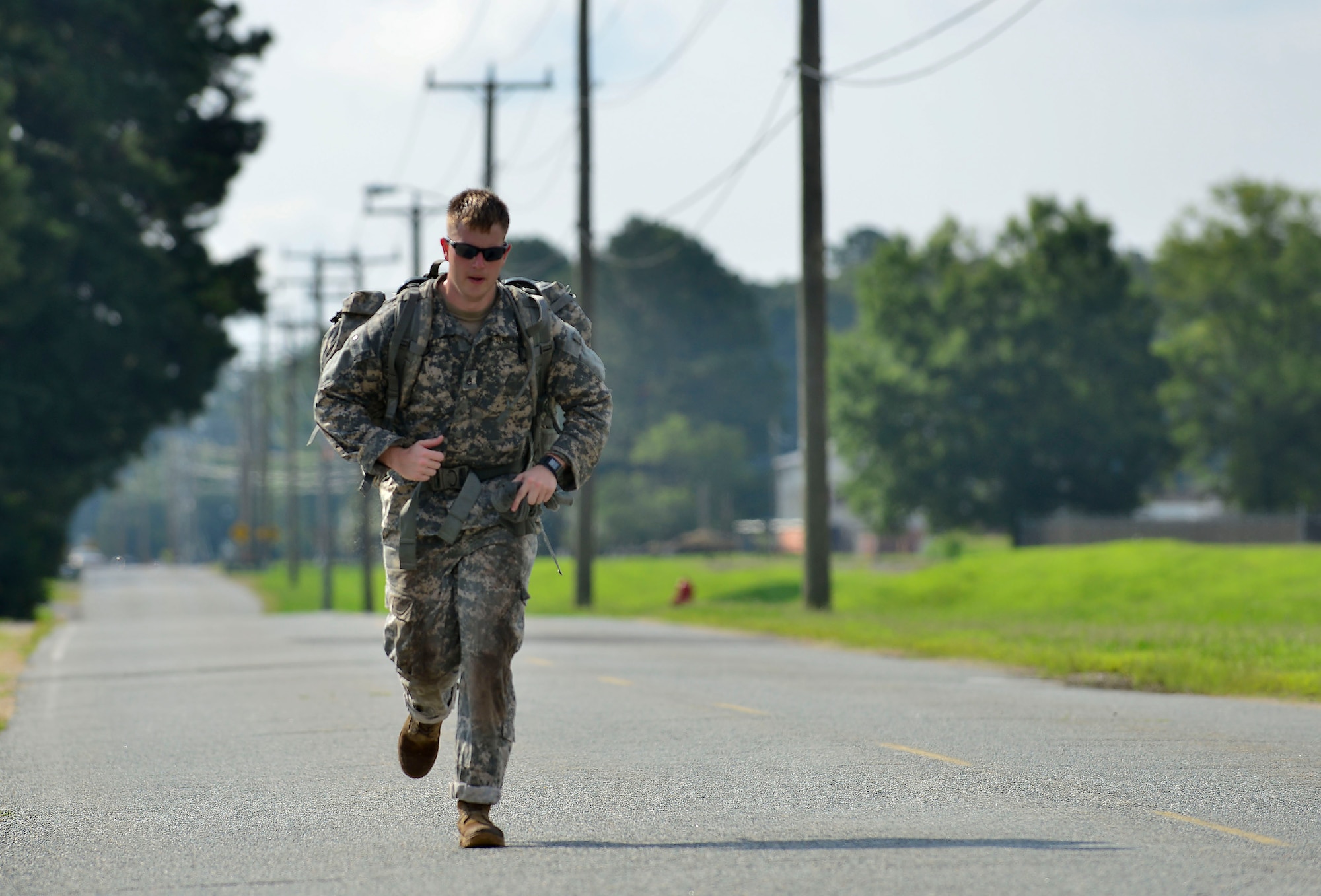 U.S. Army Staff Sgt. Jeffrey Jewell, 128th Aviation Brigade 1st-210th Aviation Regiment instructor, runs to catch up with his team mates during the ruck march Highlander Challenge at Fort Eustis, Va., July 13, 2015. The ruck march was the final event and each team had to cross the finish line together to earn points. (U.S. Air Force photo by Staff Sgt. Natasha Stannard/Released)