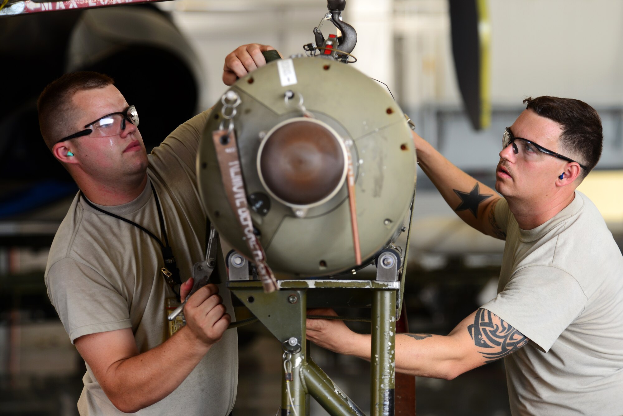 Senior Airman David Hansen, 2nd Aircraft Maintenance Squadron, left, and Staff Sgt. Adolfo Trujillo, 2nd Maintenance Group, secure a bomb onto a lift during a load crew of the quarter competition at Barksdale Air Force Base, La., July 10, 2015. The competition judged weapons loading teams on how quickly and safely they were able to load weapons onto a B-52 Stratofortress. (U.S. Air Force photo/Airman 1st Class Luke Hill)