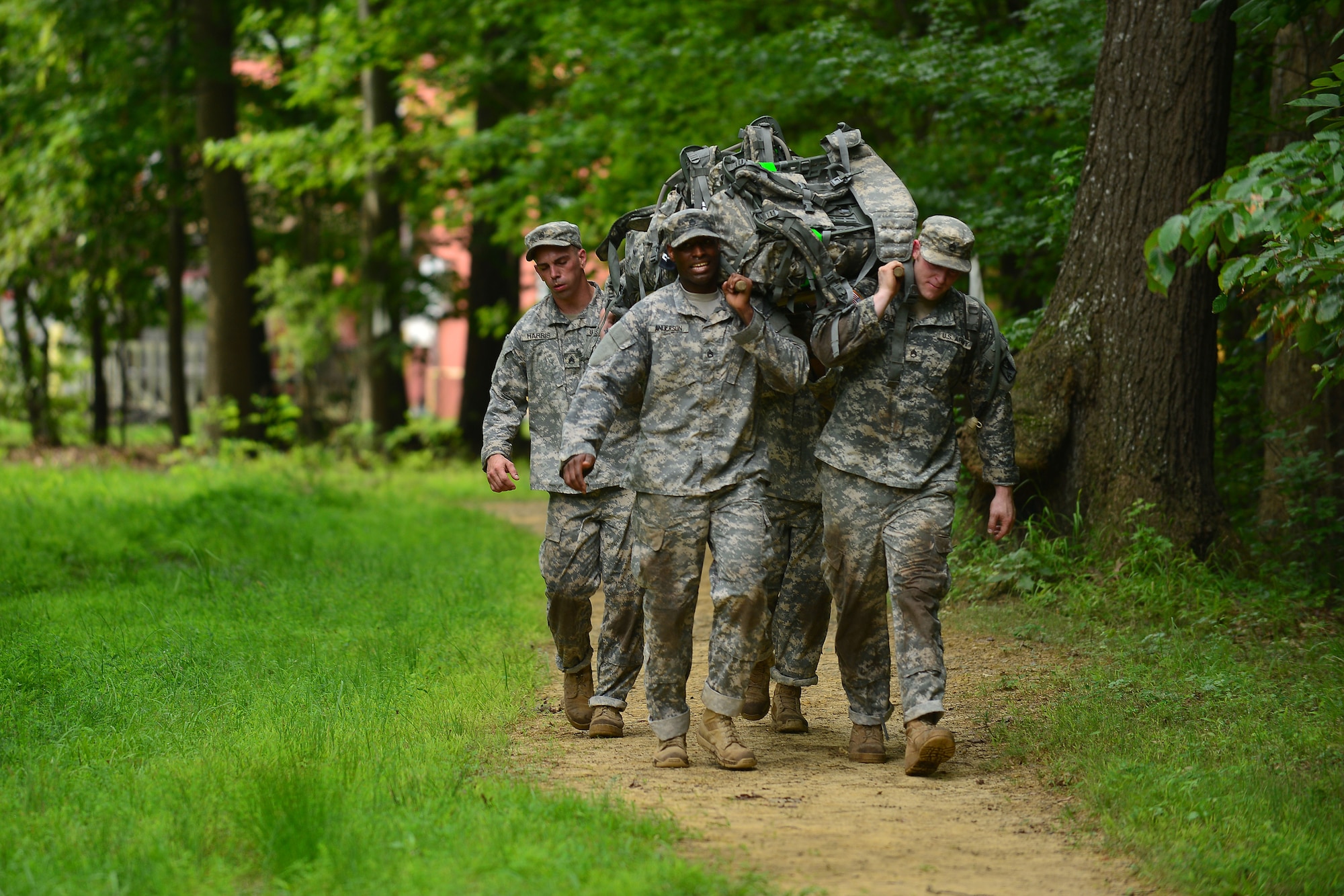 Members of the 128th Aviation Brigade 1st-210th Aviation Regiment reach the end of the 1 mile litter carry during Highlander Challenge at Fort Eustis, Va., July 13, 2015. Before the end of the carry, teams also had to complete a series of timed pull-ups. (U.S. Air Force photo by Staff Sgt. Natasha Stannard/Released)