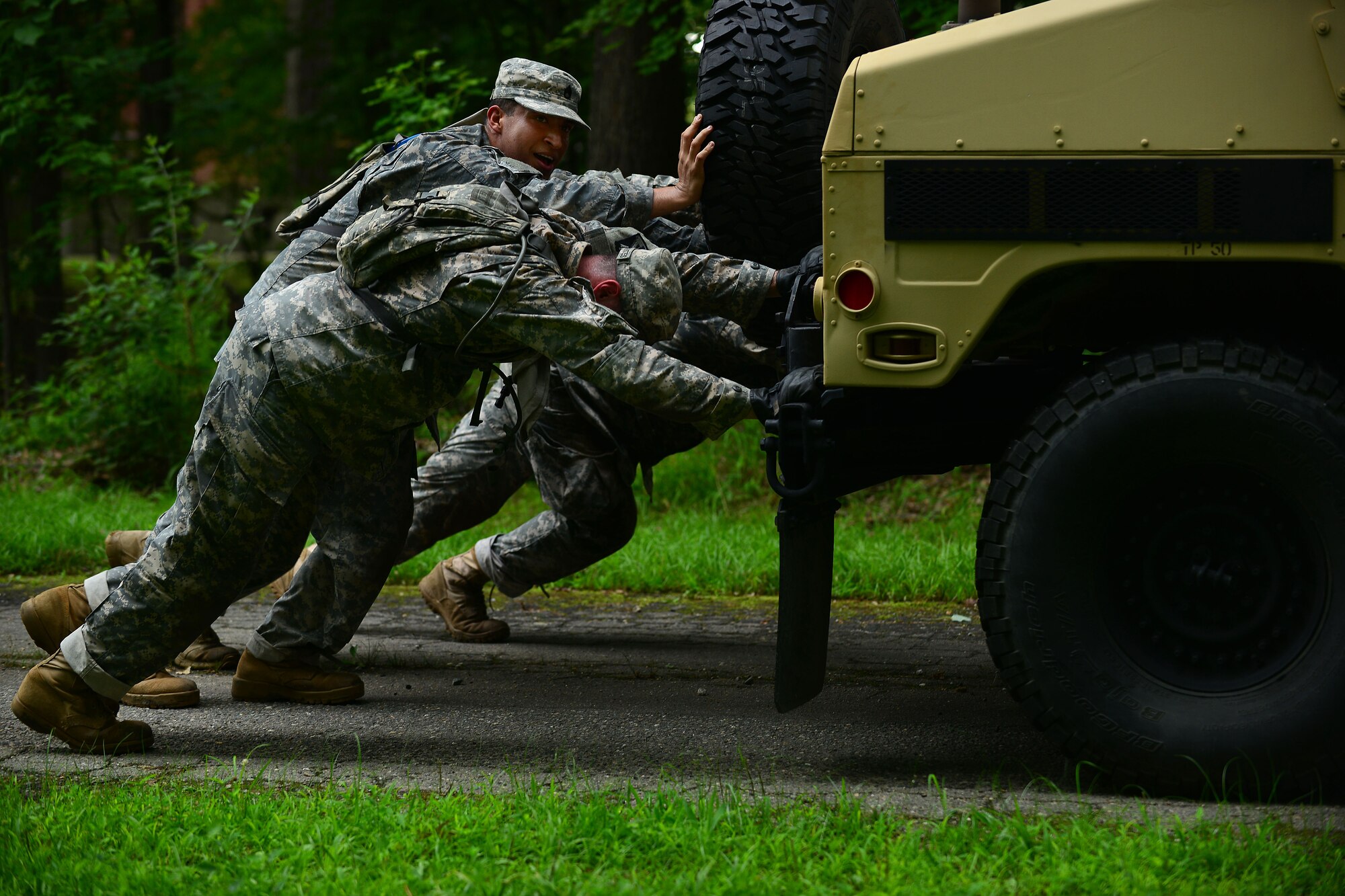 Members of the 128th Aviation Brigade 1st-210th Aviation Regiment push a 1.2 ton HUMVEE 0.1 mile during the Highlander Challenge at Fort Eustis, Va., July 13, 2015. The 128th Avn. Bde., 1st-210th Avn. Rgt. created the challenge this year, and plans to make the activity an annual event to build camaraderie and cohesion. (U.S. Air Force photo by Staff Sgt. Natasha Stannard/Released) 