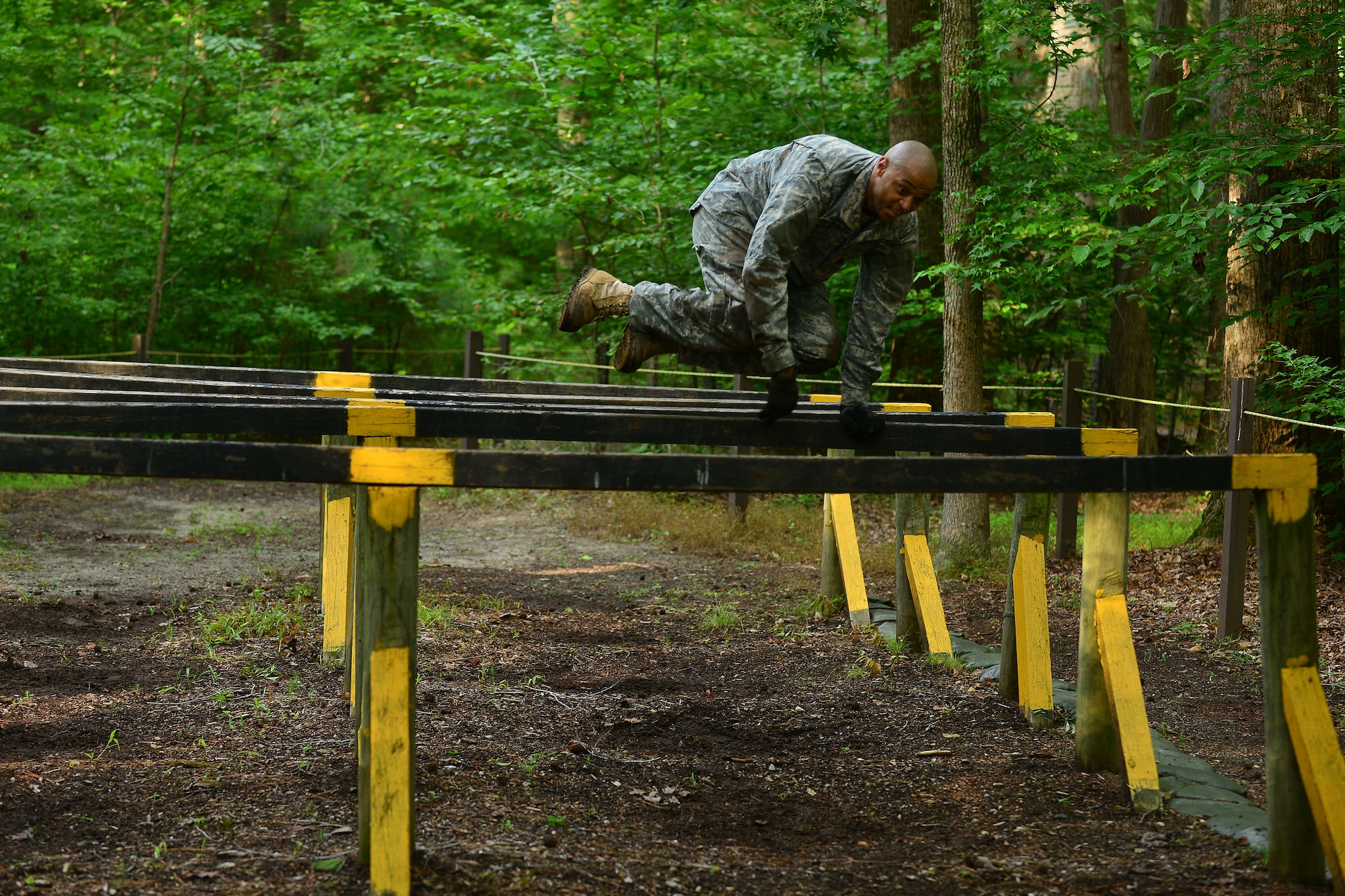 U.S. Army Sgt. 1st Class Cedric Ridgeway, 128th Aviation Brigade 1st-210th Aviation Regiment instructor, hurdles a vault during the Highlander Challenge at Fort Eustis, Va., July 13, 2015. The challenge involved various physical challenges requiring teamwork to boost camaraderie. (U.S. Air Force photo by Staff Sgt. Natasha Stannard/Released)



