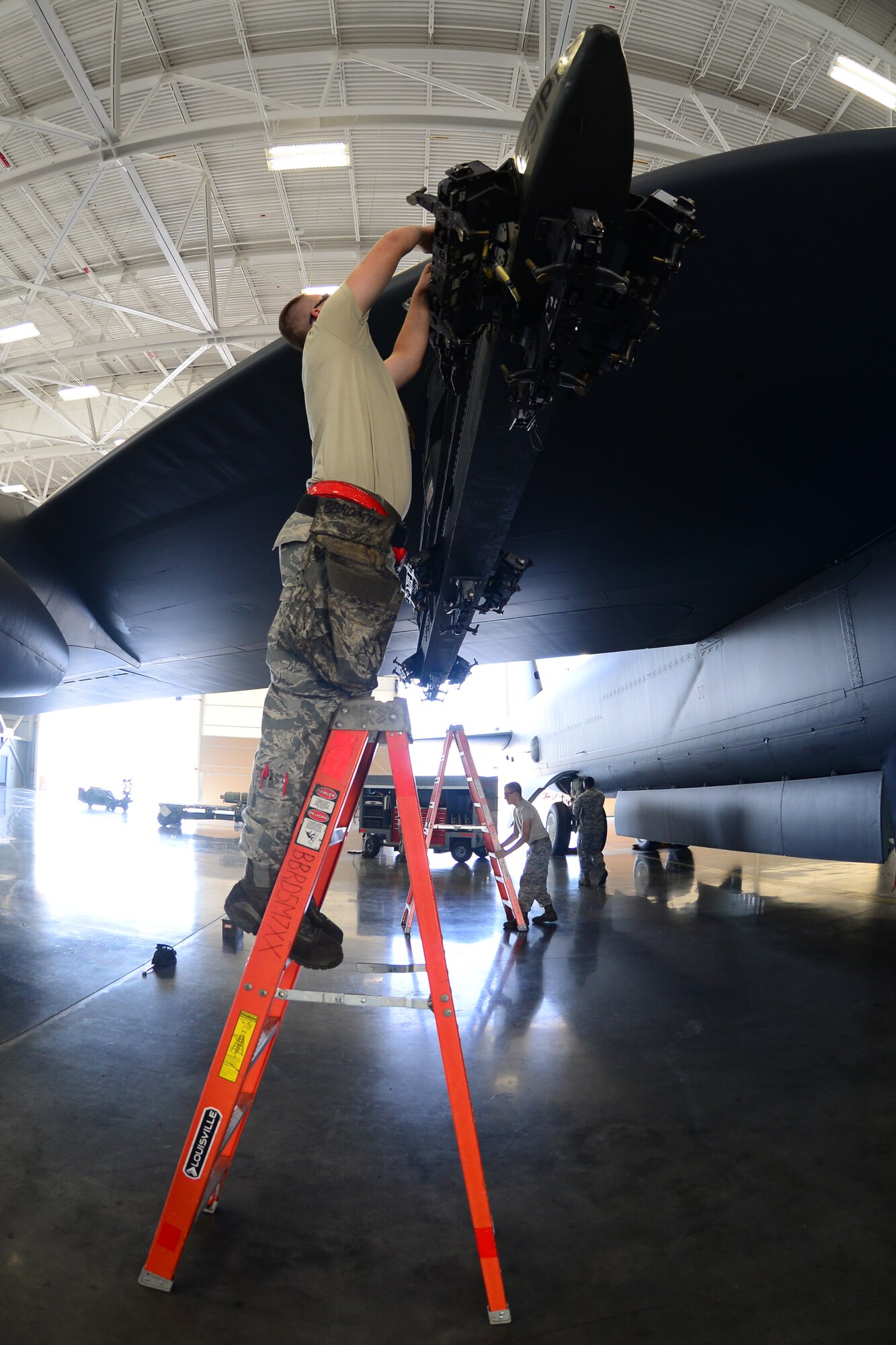 Airmen from the 2nd Aircraft Maintenance Squadron prepare to load two CBU-103’s on a B-52 Stratofortress inside the weapons load training facility during a load crew of the quarter competition at Barksdale Air Force Base, La., July 10, 2015. Two four-man teams from the 2nd AMXS competed to see which team could inspect, prepare and load weapons onto the B-52 with the least amount of discrepancies. (U.S. Air Force photo/Airman 1st Class Luke Hill)