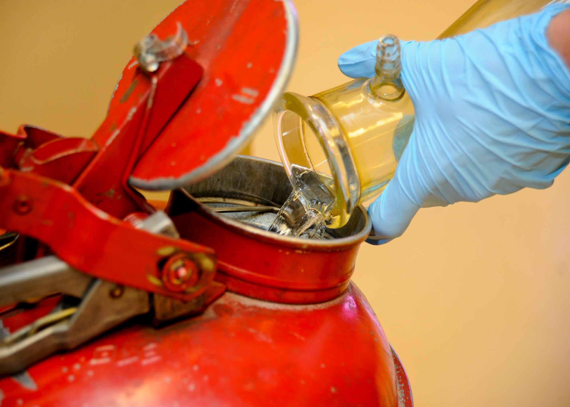 Senior Airman Steven McCarthy, 22nd Logistics Readiness Squadron Petroleum, Oils and Lubricants flight fuels laboratory technician, dumps fuel which was used for testing into a secure container, July 14, 2015, at McConnell Air Force Base, Kan. The proper handling and disposal of all fuel is a vital part of preventing hazardous spills. (U.S. Air Force photo by Senior Airman Victor J. Caputo)