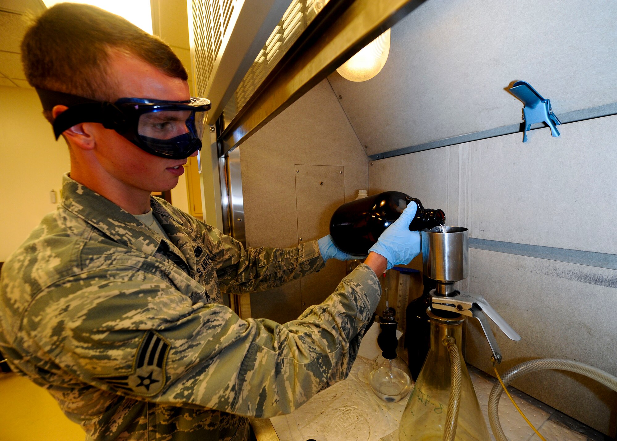 Senior Airman Steven McCarthy, 22nd Logistics Readiness Squadron Petroleum, Oils and Lubricants flight fuels laboratory technician, pours fuel through a filter, July 14, 2015, at McConnell Air Force Base, Kan. This process tests fuel for particulate contamination, which can prevent an aircraft from functioning or cause severe problems during flight if untreated. (U.S. Air Force photo by Senior Airman Victor J. Caputo)