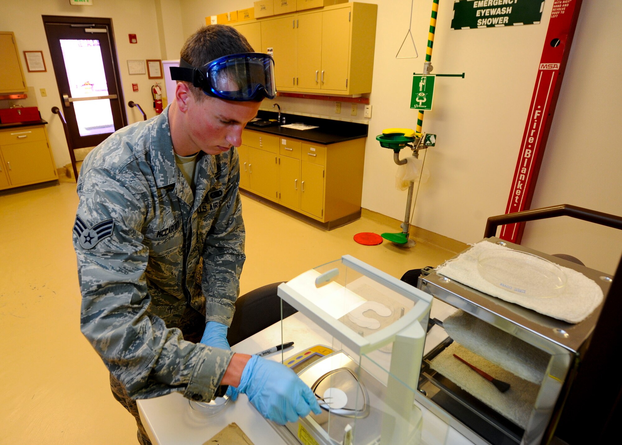Senior Airman Steven McCarthy, 22nd Logistics Readiness Squadron Petroleum, Oils and Lubricants flight fuels laboratory technician, places a membrane filter onto a scale, July 14, 2015, at McConnell Air Force Base, Kan. Each filter is weighed before use in tests to determine the amount of contaminants caught. (U.S. Air Force photo by Senior Airman Victor J. Caputo)