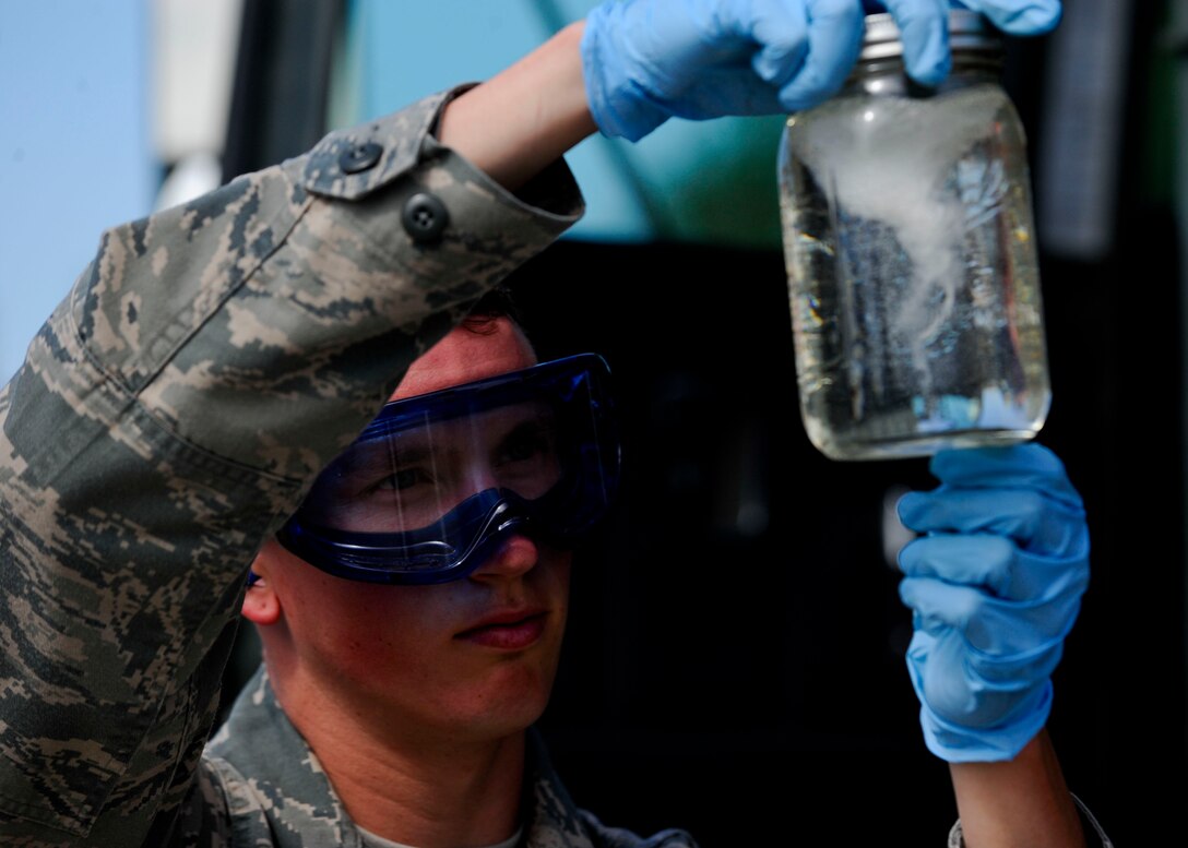 Senior Airman Steven McCarthy, 22nd Logistics Readiness Squadron Petroleum, Oils and Lubricants flight fuels laboratory technician, examines a jar of fuel for visual contamination, July 14, 2015, at McConnell Air Force Base, Kan. Visual inspection is one of the first steps in the process to check fuel for particular contamination, which can cause serious mechanical problems on aircraft if left untreated. (U.S. Air Force photo by Senior Airman Victor J. Caputo)