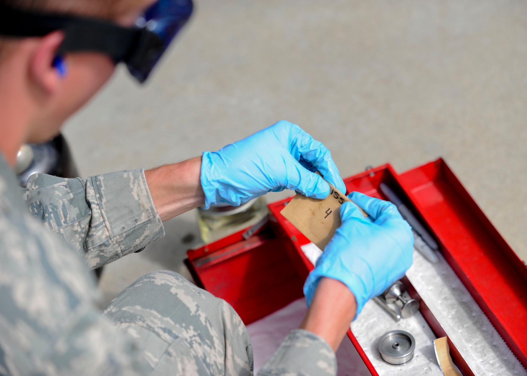 Senior Airman Steven McCarthy, 22nd Logistics Readiness Squadron Petroleum, Oils and Lubricants flight fuels laboratory technician, seals a water detection pad package for testing back in the fuels lab, July 14, 2015, at McConnell Air Force Base, Kan. The pad checks for water contamination in the fuel. If the water molecules freeze during flight at high altitude, dangerous malfunctions are more likely to occur. (U.S. Air Force photo by Senior Airman Victor J. Caputo)