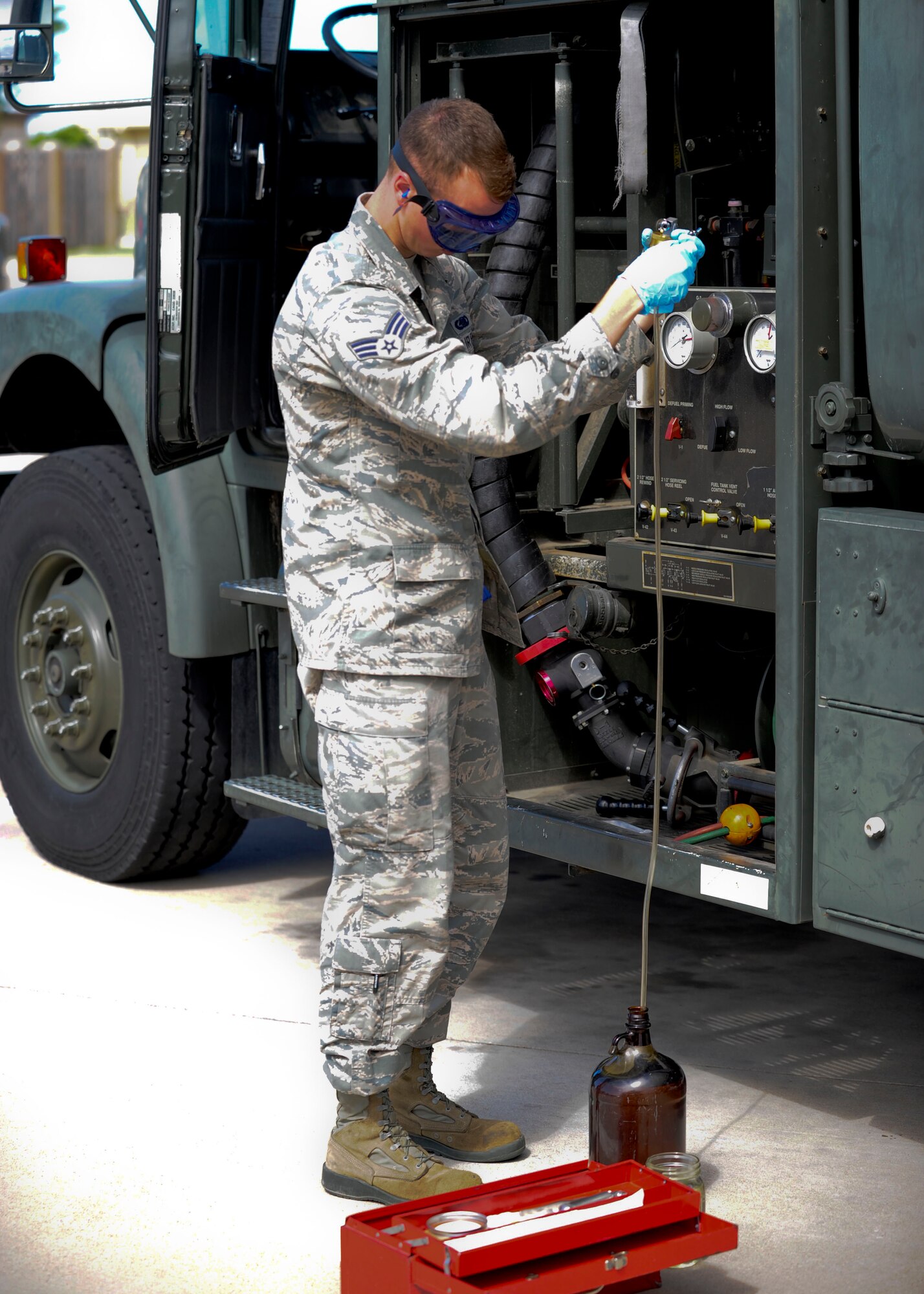Senior Airman Steven McCarthy, 22nd Logistics Readiness Squadron Petroleum, Oils and Lubricants flight fuels laboratory technician, clears the remaining fuel out of a tube after drawing a gallon of fuel from a R-11 fuel truck for testing, July 14, 2015, at McConnell Air Force Base, Kan. McCarthy tests the fuel from an average of four trucks a week, where he will use one quart for a visual sample and one gallon to test back in the fuels laboratory. (U.S. Air Force photo by Senior Airman Victor J. Caputo)