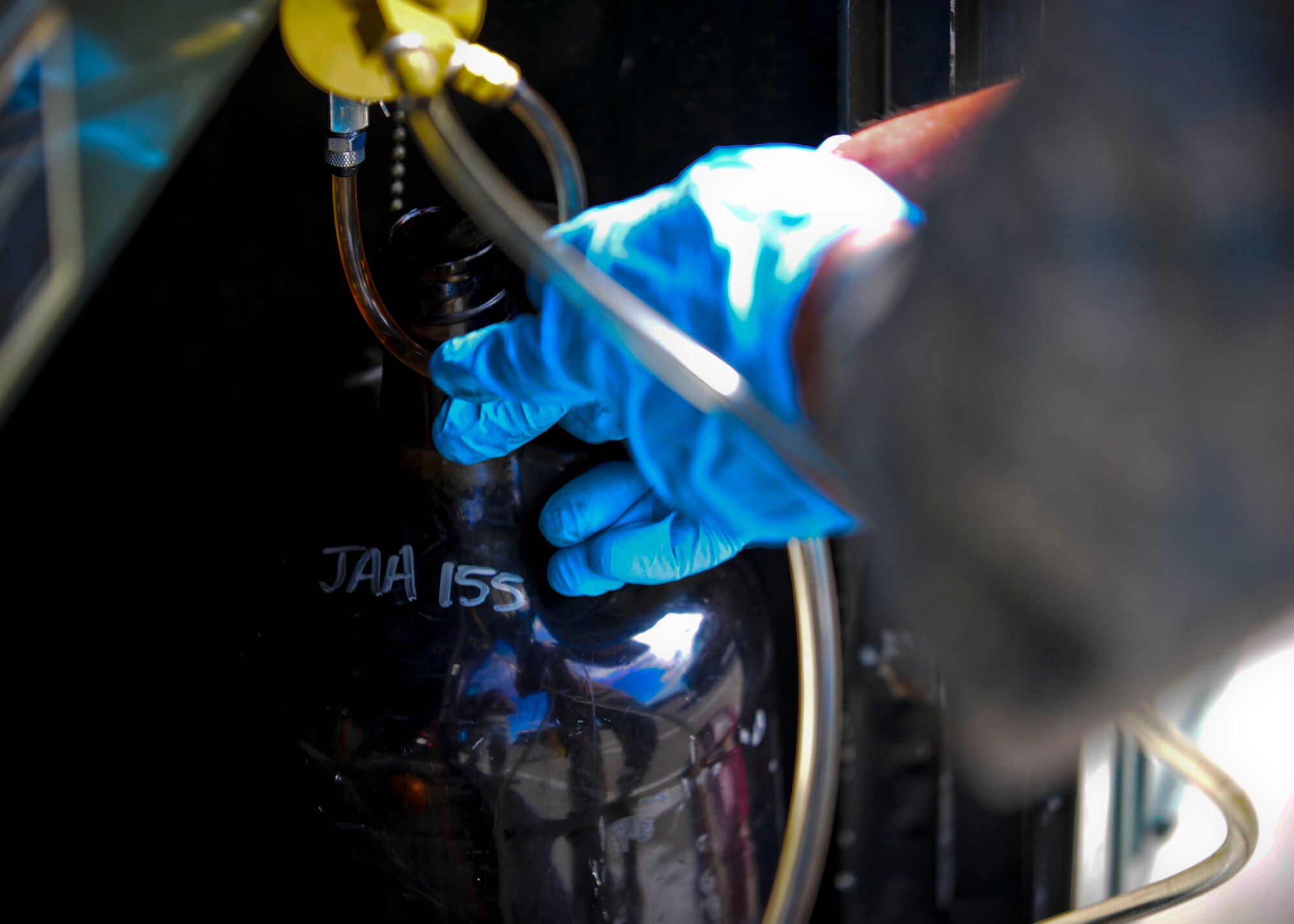 Senior Airman Steven McCarthy, 22nd Logistics Readiness Squadron Petroleum, Oils and Lubricants flight fuels laboratory technician, fills a fuel container, July 14, 2015, at McConnell Air Force Base, Kan. McCarthy pulled one gallon of fuel from an R-11 fuel truck to test for particular contamination in the fuels lab. (U.S. Air Force photo by Senior Airman Victor J. Caputo)