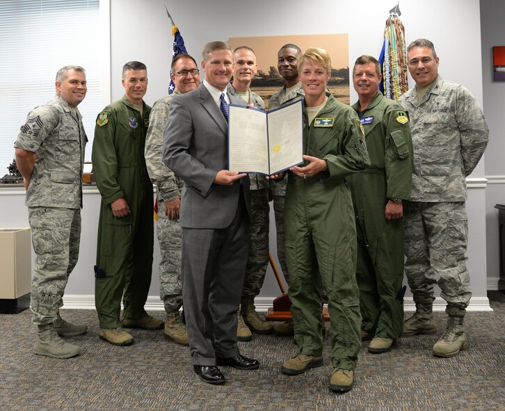 Louisiana State Senator Barrow Peacock presents Col. Kristin Goodwin, 2nd Bomb Wing commander, and 2nd BW leadership with a resolution at Barksdale Air Force Base, La., July 13, 2015. The resolution, written by Peacock, congratulates the 2nd BW for earning the 2014 Brigadier General Frederick W. Castle Award as Air Force Global Strike Command's best bomb wing of the year. Throughout 2014, 2nd BW reformed processes which earned Air Force and Department of Defense accolades punctuated by the highest possible ratings on multiple major inspections. "Whether it is their role in the Nuclear Enterprise, supporting combatant commanders or enhancing the capabilities of their base, the Airmen of Barksdale, in conjunction with community partners, are making a difference every day," the resolution reads. (U.S. Air Force photo/Airman 1st Class Curt Beach)