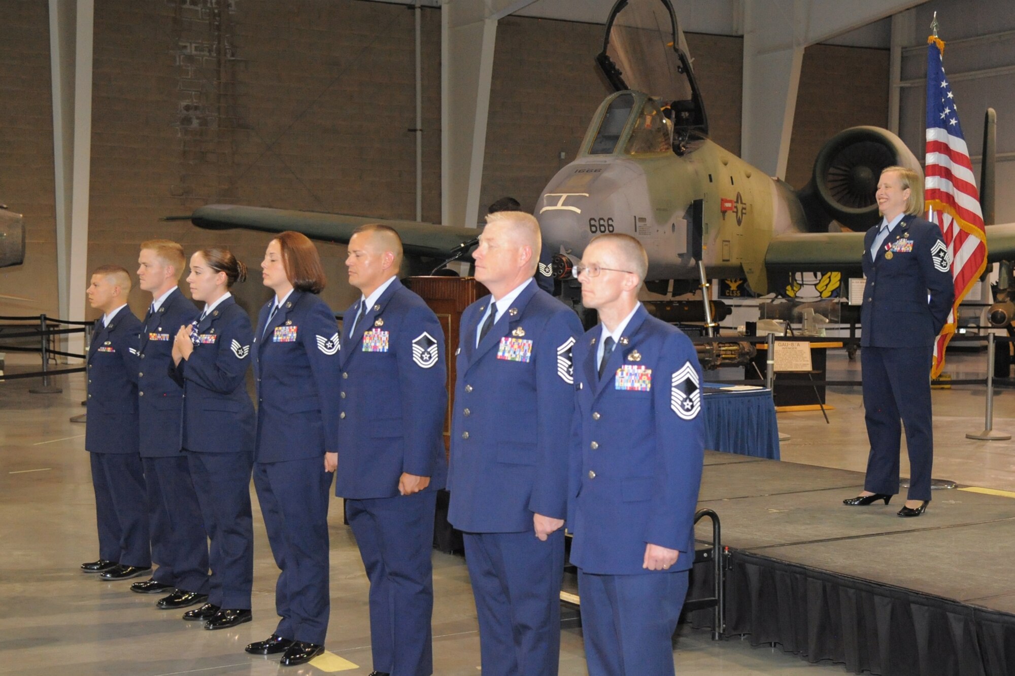 Chief Master Sgt. Rhonda K. Miller observes as Airmen conduct a flag presentation during her retirement ceremony July 14 at the Hill Aerospace Museum. During the flag presentation, the U.S. flag was passed through Air Force enlisted ranks from junior to senior Airmen, while highlights of Chief Miller’s career were narrated. (U.S. Air Force photo by Todd Cromar)
