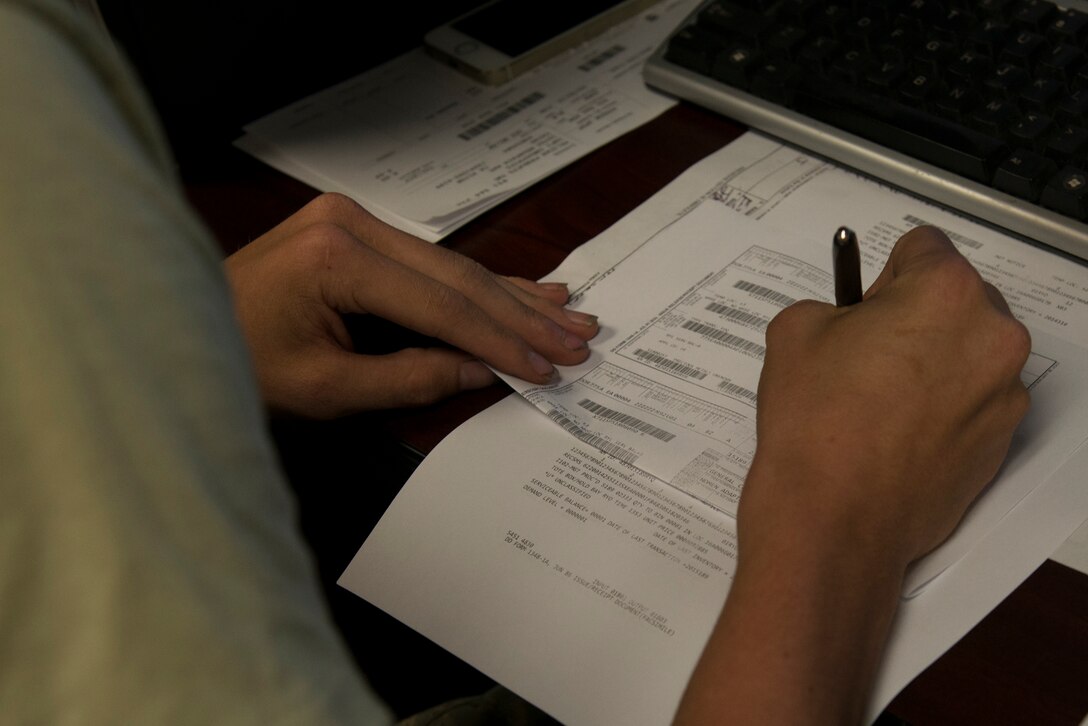 U.S. Air Force Airman 1st Class Thomas Sloan, 23d Logistics Readiness Squadron traffic management apprentice, fills out a receipt document July 8, 2015, at Moody Air Force Base, Ga. Airmen in the cargo-movement warehouse document approximately 15,000 pieces of cargo per week to keep things moving in a timely manner. (U.S. Air Force photo by Airman 1st Class Kathleen D. Bryant/Released)
