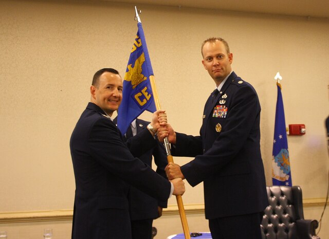 Colonel Michael Mongold, 628th Mission Support Group commander passes the guidon to Lt. Col. Matthew Brennan, the new 628th Civil Engineer Squadron commander during a change of command ceremony July 10, 2015 at Joint Base Charleston, S.C. Brennan comes to JB Charleston from Headquarters Air Force in Washington, D.C., where he was the executive officer for the Directorate of Civil Engineers. Lt. Col. Patrick Miller, the outgoing 628th CES commander is headed to Washington, D.C., where he will attend The National War College. (Courtesy photo)