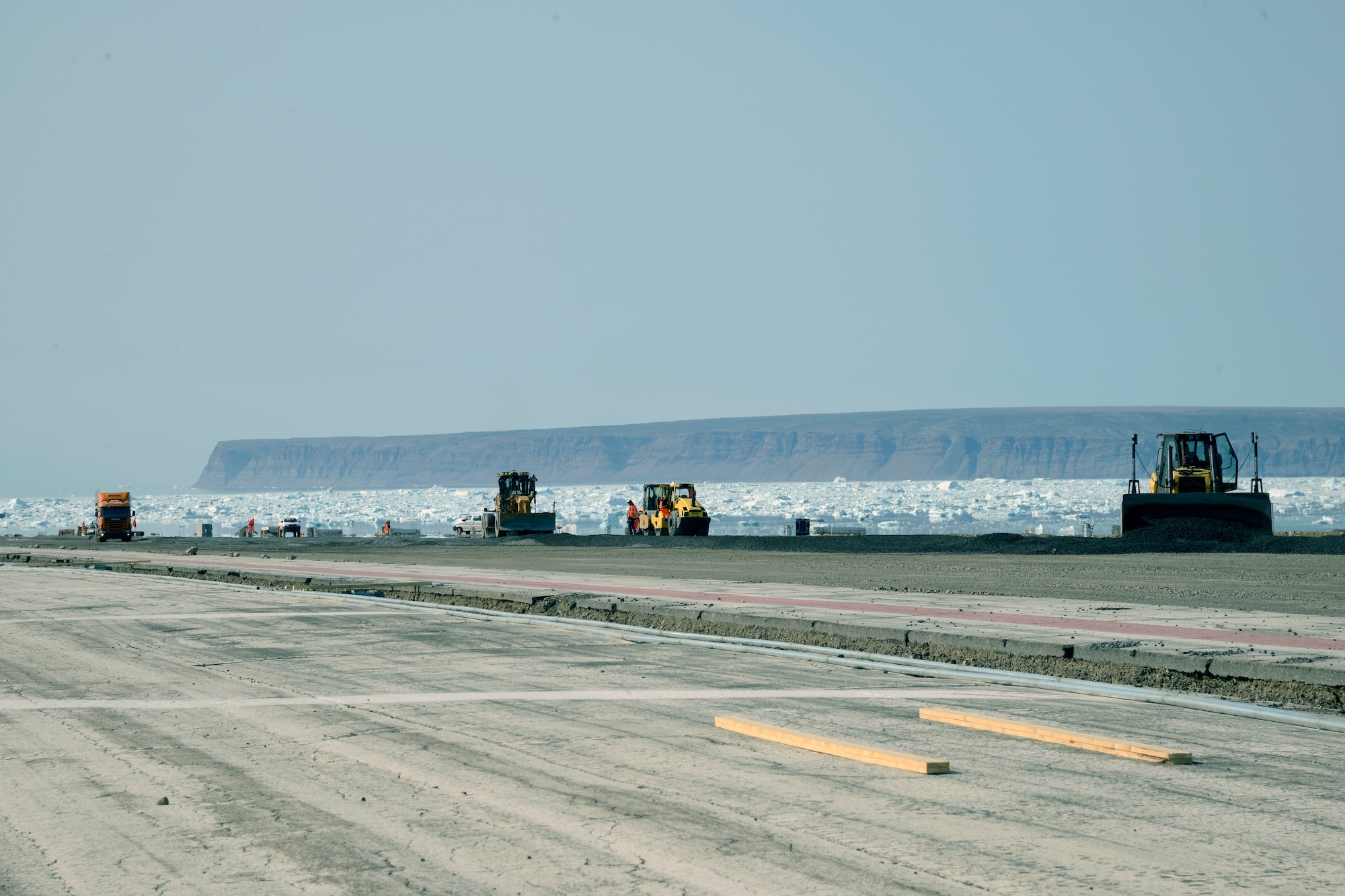 THULE AIR BASE, Greenland -- Contractors work to upgrade the Thule Air Base runway July 11, 2015. The first half of the project -- the first 5,000 feet of the 10,000 foot runway -- began in early June and is scheduled to be completed by Sept. 15. The second half of the upgrade will begin next year. (U.S. Air Force photo by Tech. Sgt. Jared Marquis)