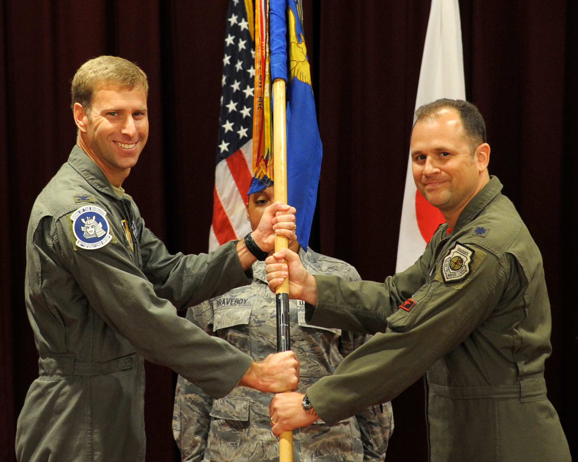 U.S. Air Force Col. David A. Mineau, 18th Operations Group commander, passes the 67th Fighter Squadron guidon to Lt. Col. James C. McFarland, 67th FS commander, during the squadron’s change of command ceremony on Kadena Air Base, Japan, July 11, 2015. McFarland was previously the director of operations for the 44th Fighter Squadron, here at Kadena Air Base. The fighter squadron is a part of the tip of the spear with the F-15's unique role in support of Pacific Command operational plans and headquarters-directed contingency operations. (U.S. Air Force photo by Airman 1st Class Zackary A. Henry)