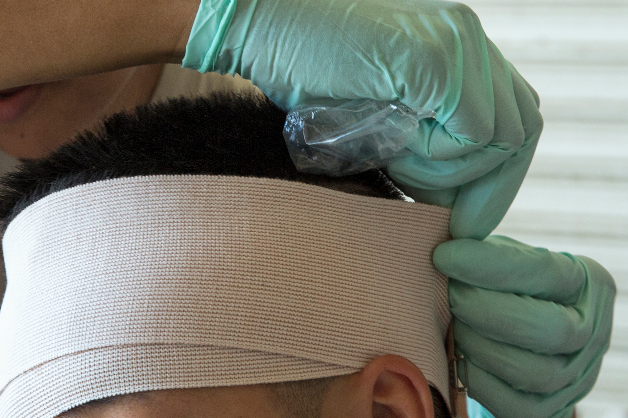 Capt. Rachel Myers, 374th Medical Operation Squadron registered nurse, treats a simulated casualty during an Emergency Management Exercise at Yokota Air Base, Japan, July 13, 2015. The EME trained Yokota for possible real-world situations requiring response and communication between on-base organizations. (U.S. Air Force photo by Osakabe Yasuo/Released)