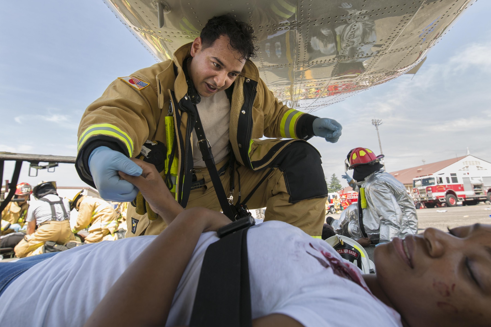 Tech. Sgt. Stephen Sanabria, 374th Civil Engineer Squadron fire fighter, checks the vitals of a simulated victim during an Emergency Management Exercise, July 13, 2015. The EME trained Yokota for possible real-world situations requiring response and communication between on-base organizations. (U.S. Air Force photo by Osakabe Yasuo/Released)