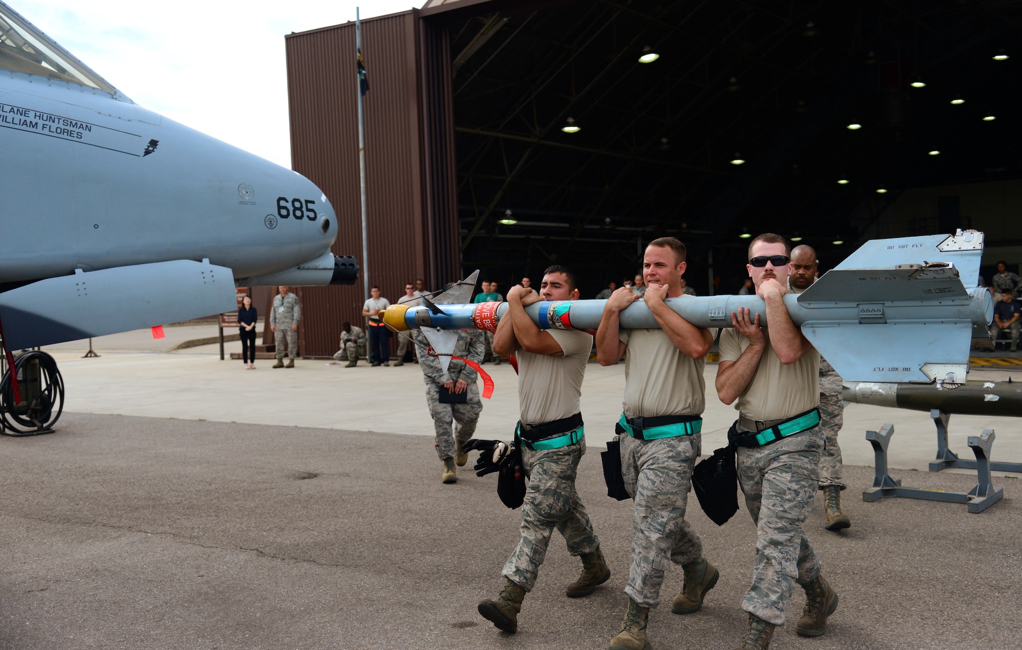 The U.S. Air Force 25th Aircraft Maintenance Unit load team carries an air-to-air missile to their A-10 Thunderbolt II during the quarterly weapons load competition at Osan Air Base, Republic of Korea, July 10, 2015. The event adds an element of competition to a qualification test for the technicians; competitors must complete a written test and a practical demonstration of skill within a fixed amount of time in order to maintain mission readiness status. (U.S. Air Force photo by Staff Sgt. Amber Grimm/Released)
