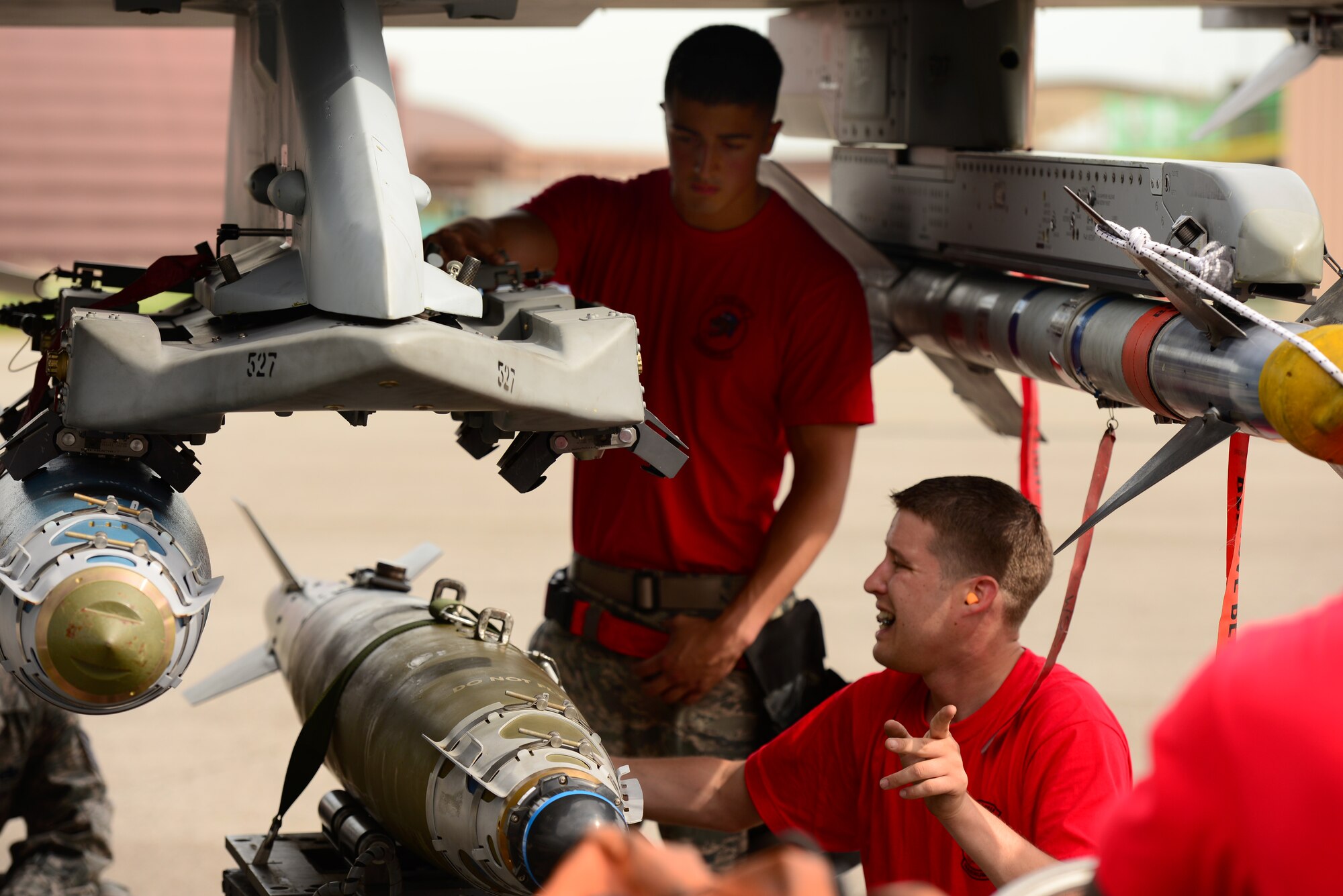 U.S. Air Force Staff Sgt. Kevin Vinson, 36th Aircraft Maintenance Unit weapons loader, directs the loading of practice munitions during the quarterly load competition held at Osan Air Base, Republic of Korea, July 10, 2015. The event adds an element of competition to a qualification test for the technicians; competitors must complete a written test and a practical demonstration of skill within a fixed amount of time in order to maintain mission readiness status. (U.S. Air Force photo by Staff Sgt. Amber Grimm/Released)