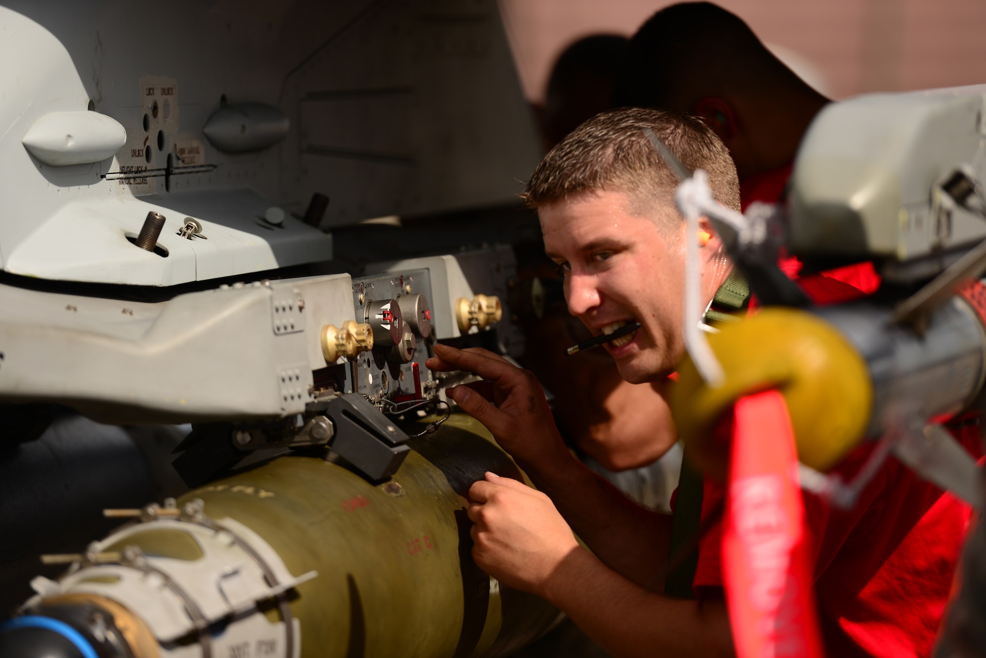 U.S. Air Force Staff Sgt. Kevin Vinson, 36th Aircraft Maintenance Unit weapons loader, directs the loading of practice munitions during the quarterly load competition held at Osan Air Base, Republic of Korea, July 10, 2015. The event adds an element of competition to a qualification test for the technicians; competitors must complete a written test and a practical demonstration of skill within a fixed amount of time in order to maintain mission readiness status. (U.S. Air Force photo by Staff Sgt. Amber Grimm/Released)